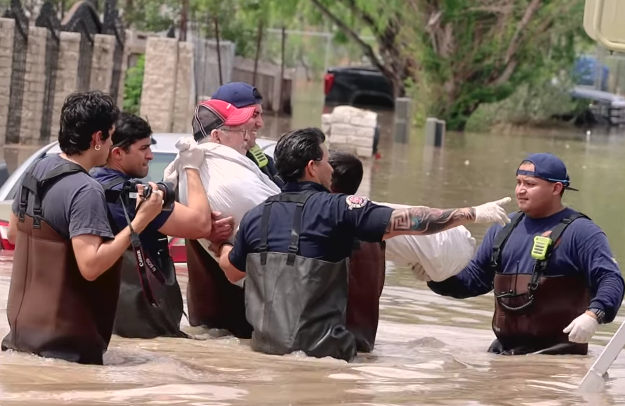 Rescue team helping a person during a flooding incident