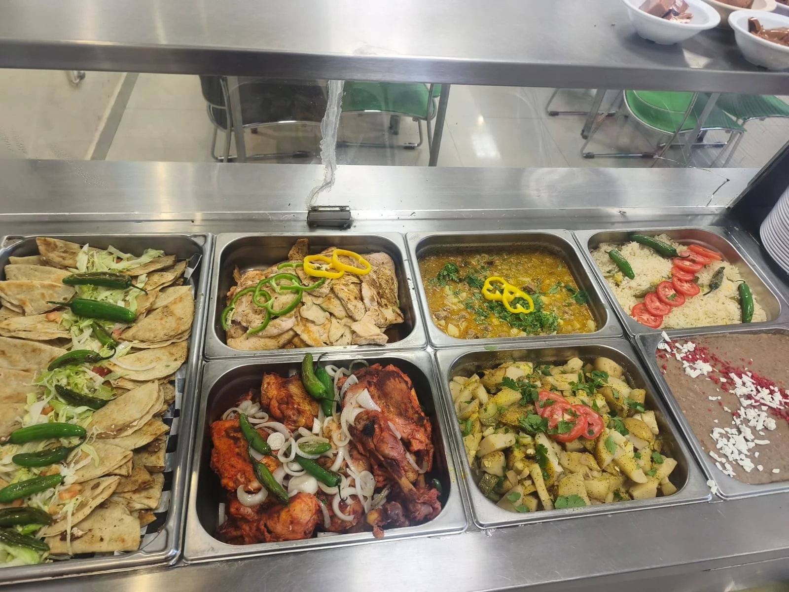 Variedad de platos típicos mexicanos en una máquina de comida. Incluye tacos, pollo con verduras, guacamole con totopos, entre otros.
