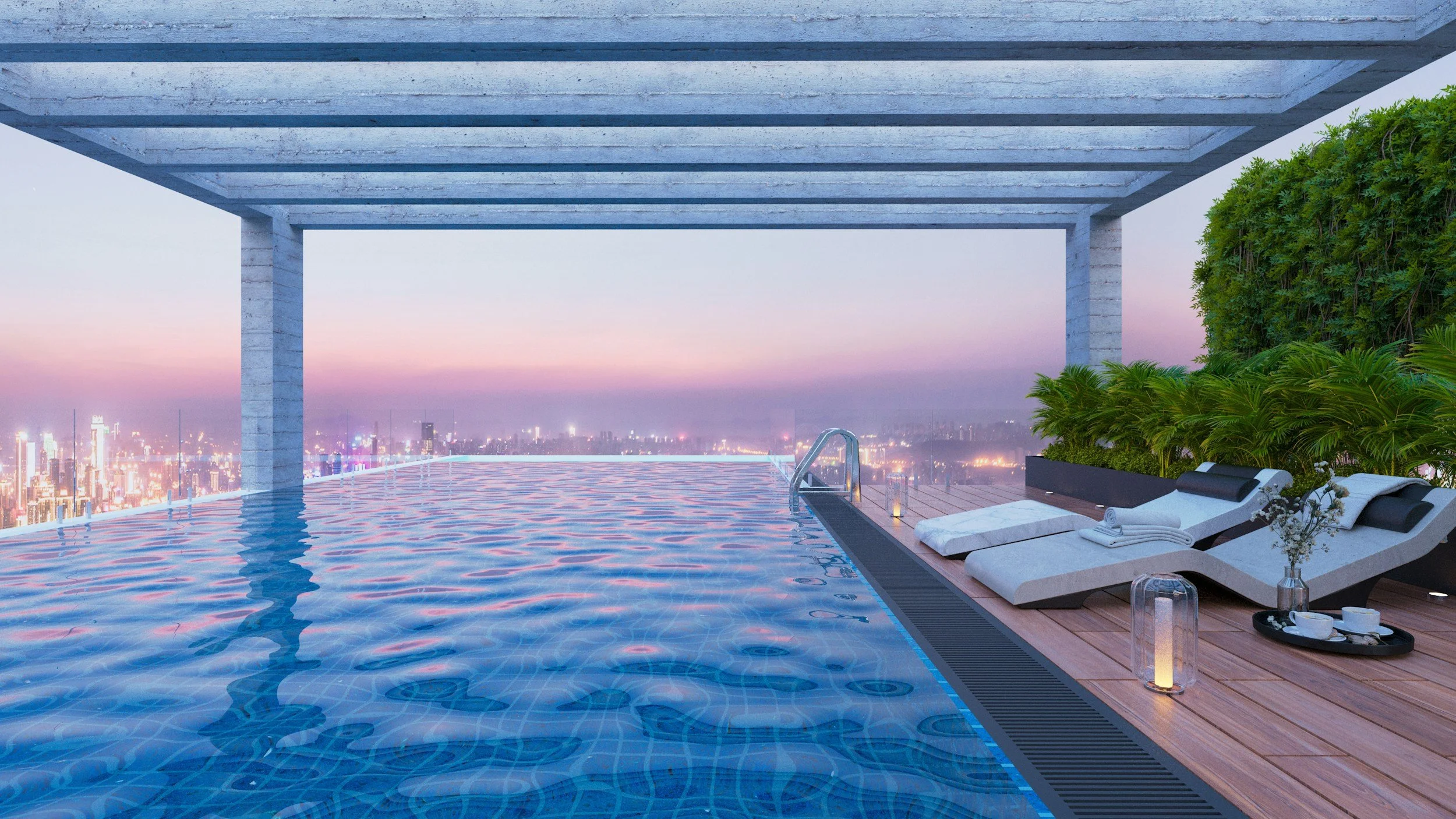 A rooftop infinity pool overlooking a city skyline at dusk, with lounge chairs, towels, drinks, and greenery on a wooden deck.