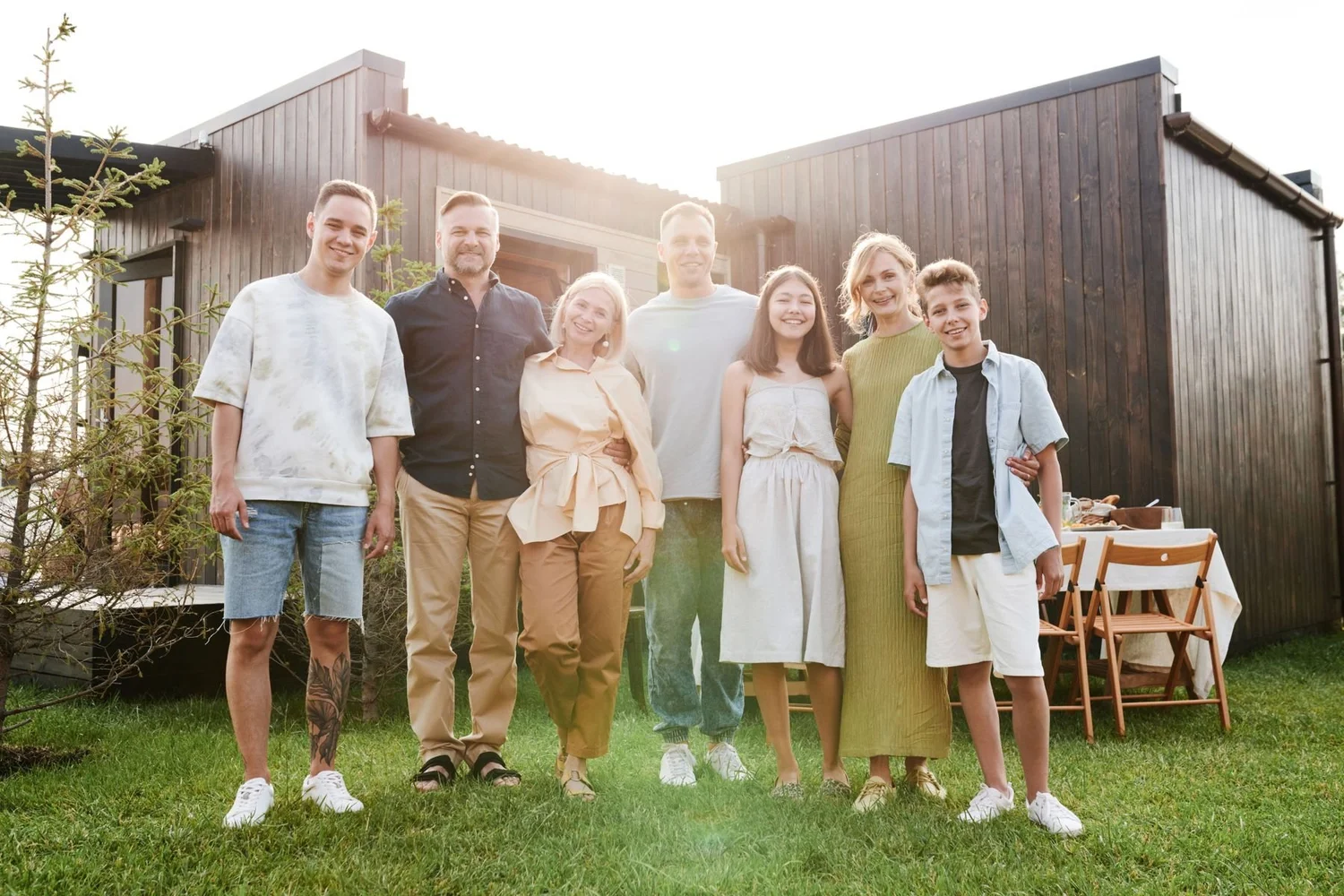 An extended family standing together in front of their house
