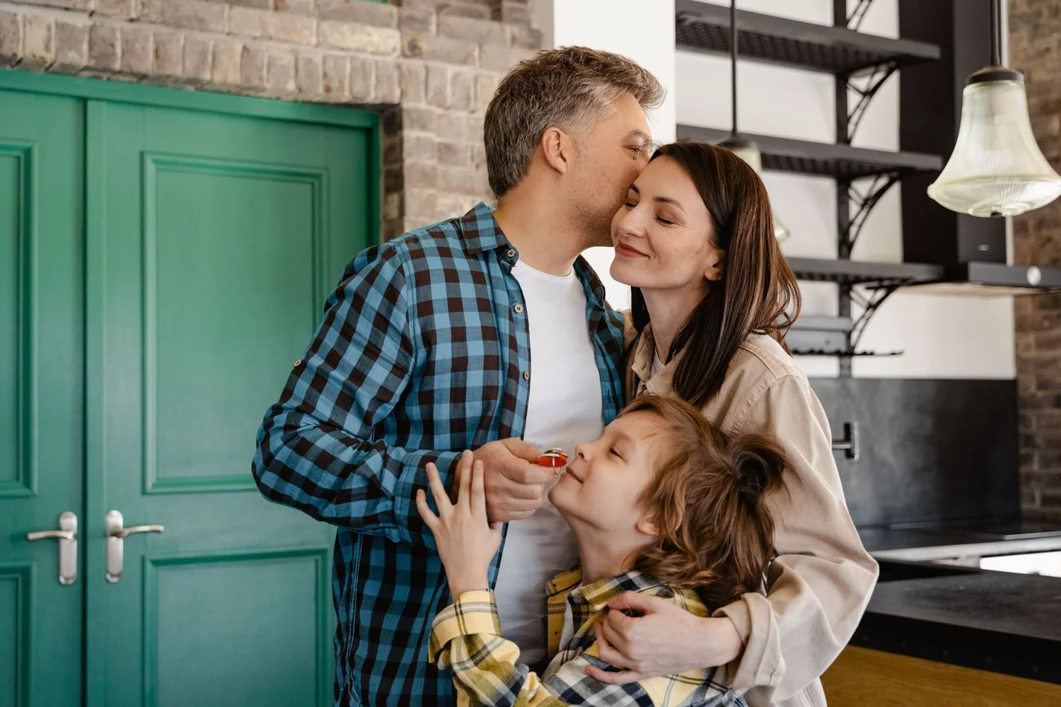 A family at their front door, the son holding the keys to their new home