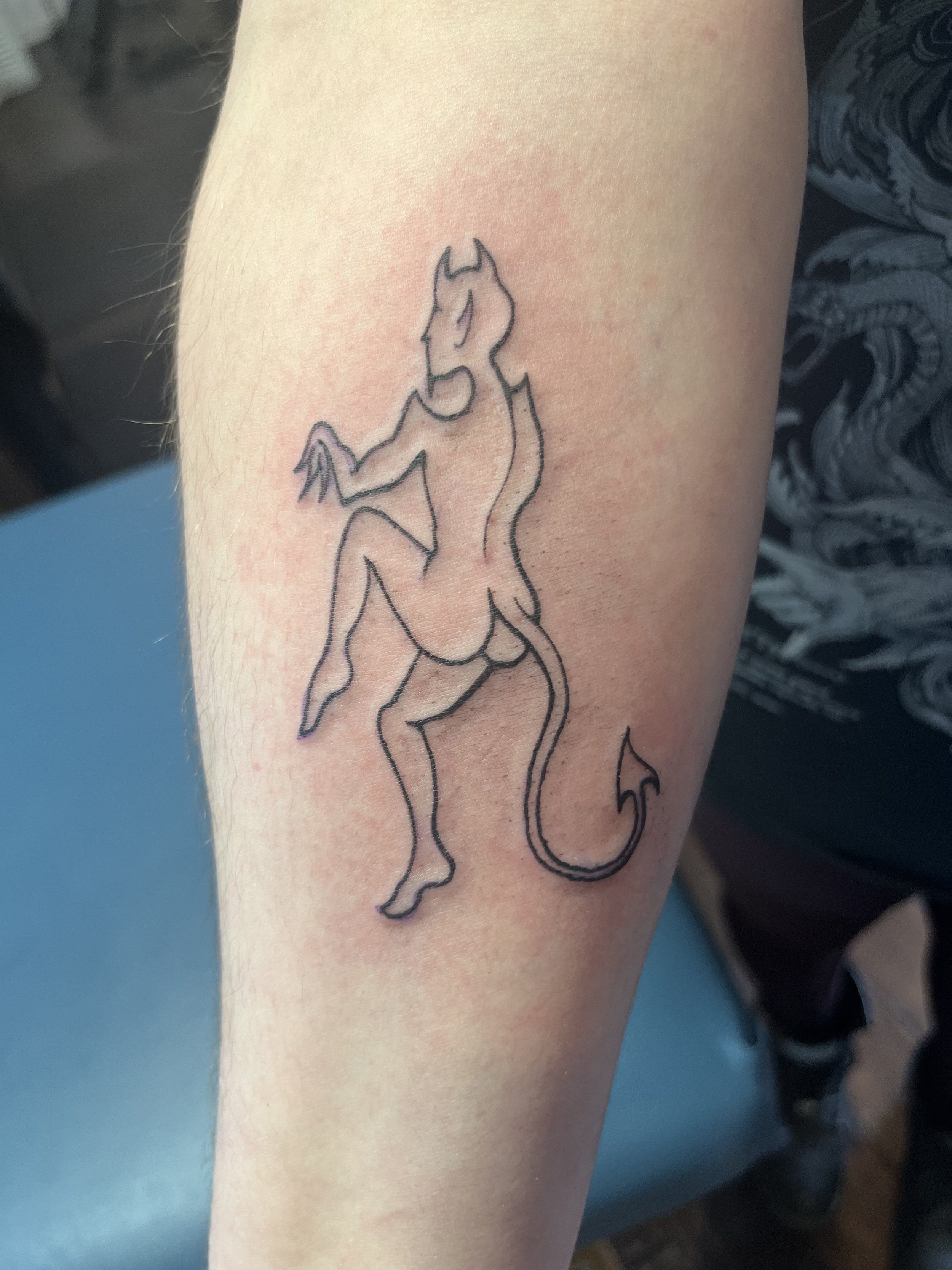A tattoo of a unicorn with a flowing mane on a person's upper arm.