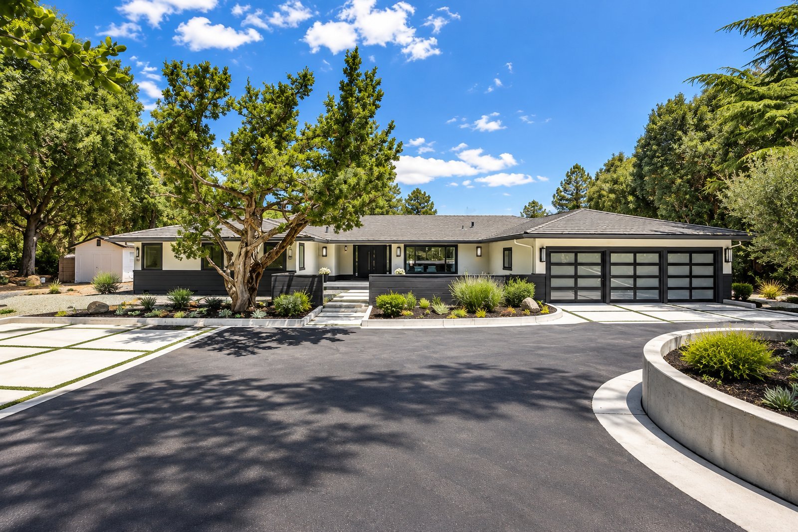 Mid-century ranch home with a wide driveway under a blue sky