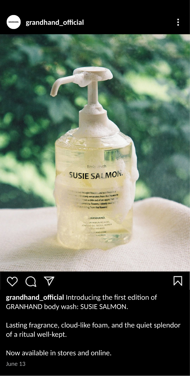 An Instagram post featuring a clear bottle of Susie Salmon body wash with a pump dispenser, foam on top, set against a blurred green outdoor background.