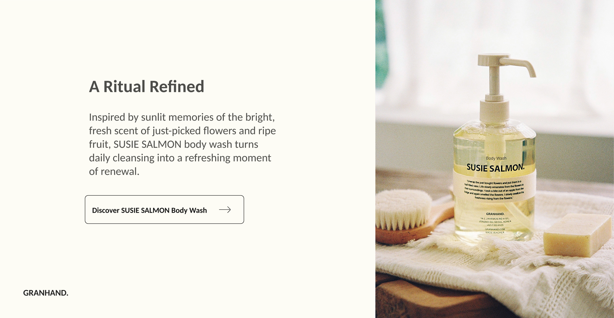 A webpage featuring Susie Salmon body wash with a description of inspired, sunlit memories and renewal. The page includes a button to discover the body wash. The right side shows a bottle of Susie Salmon body wash with a pump, a natural sponge, and a soap bar on a textured cloth, with a softly lit background.