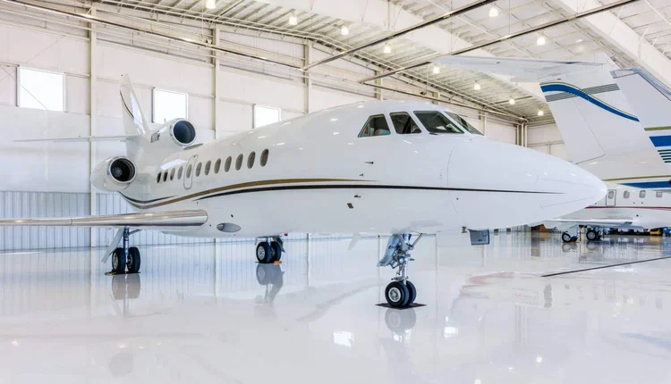 Luxury private jet inside a spacious hangar.