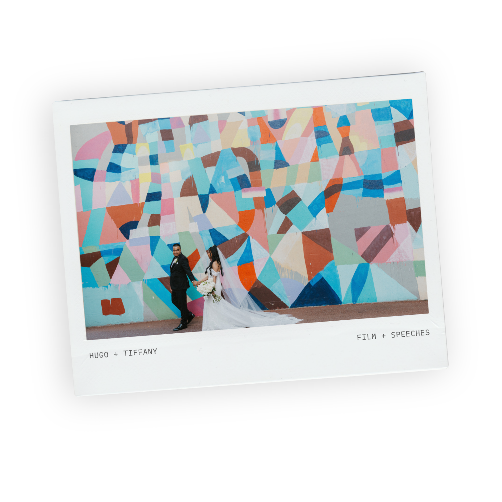 Bride and groom walking past a colourful geometric mural