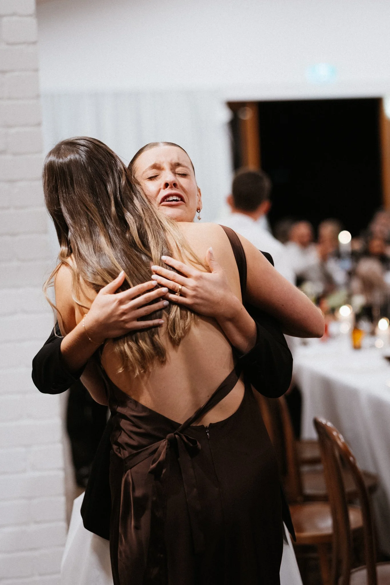 Two guests sharing an emotional hug at the reception