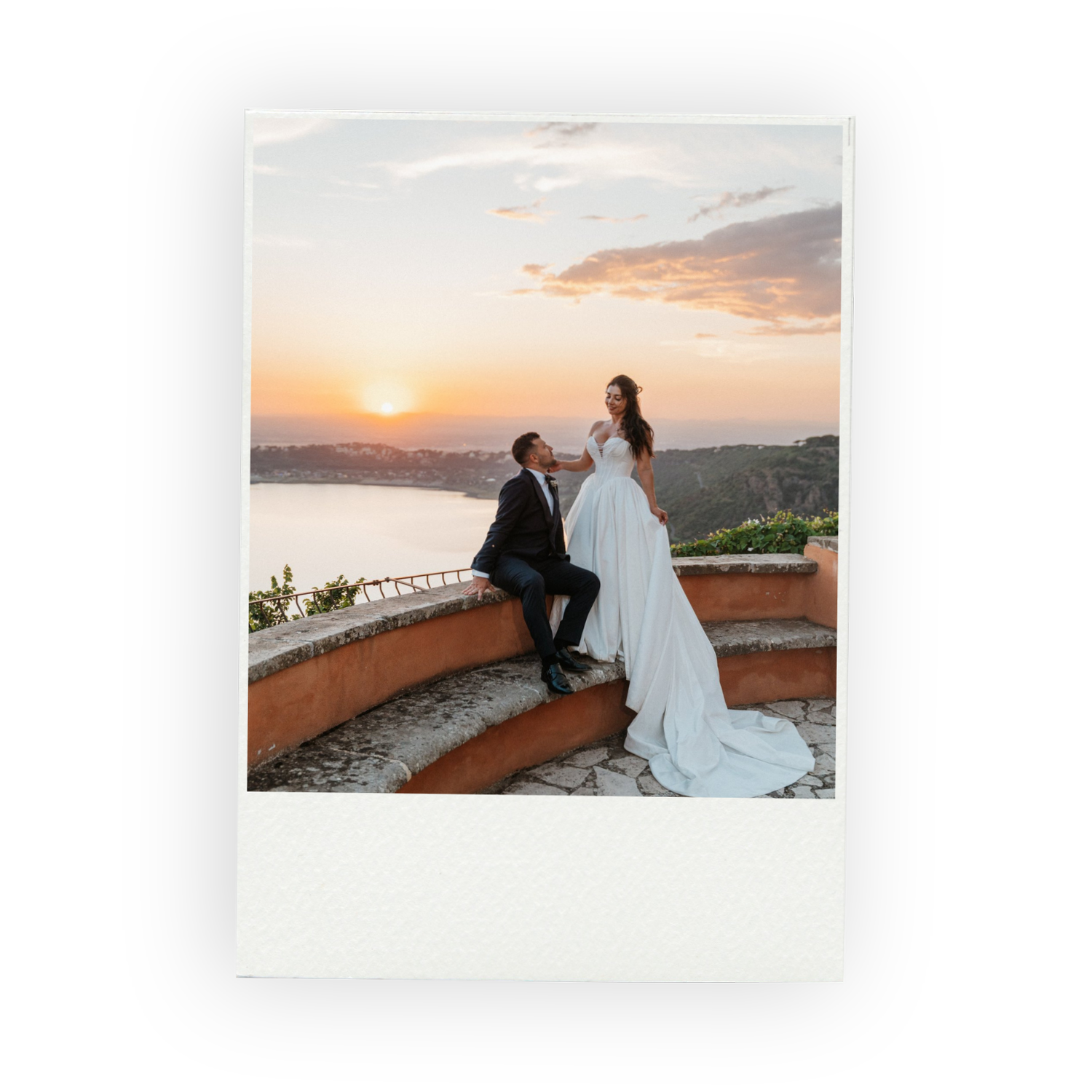 Bride and groom on a terrace at sunset, overlooking a lake in Italy