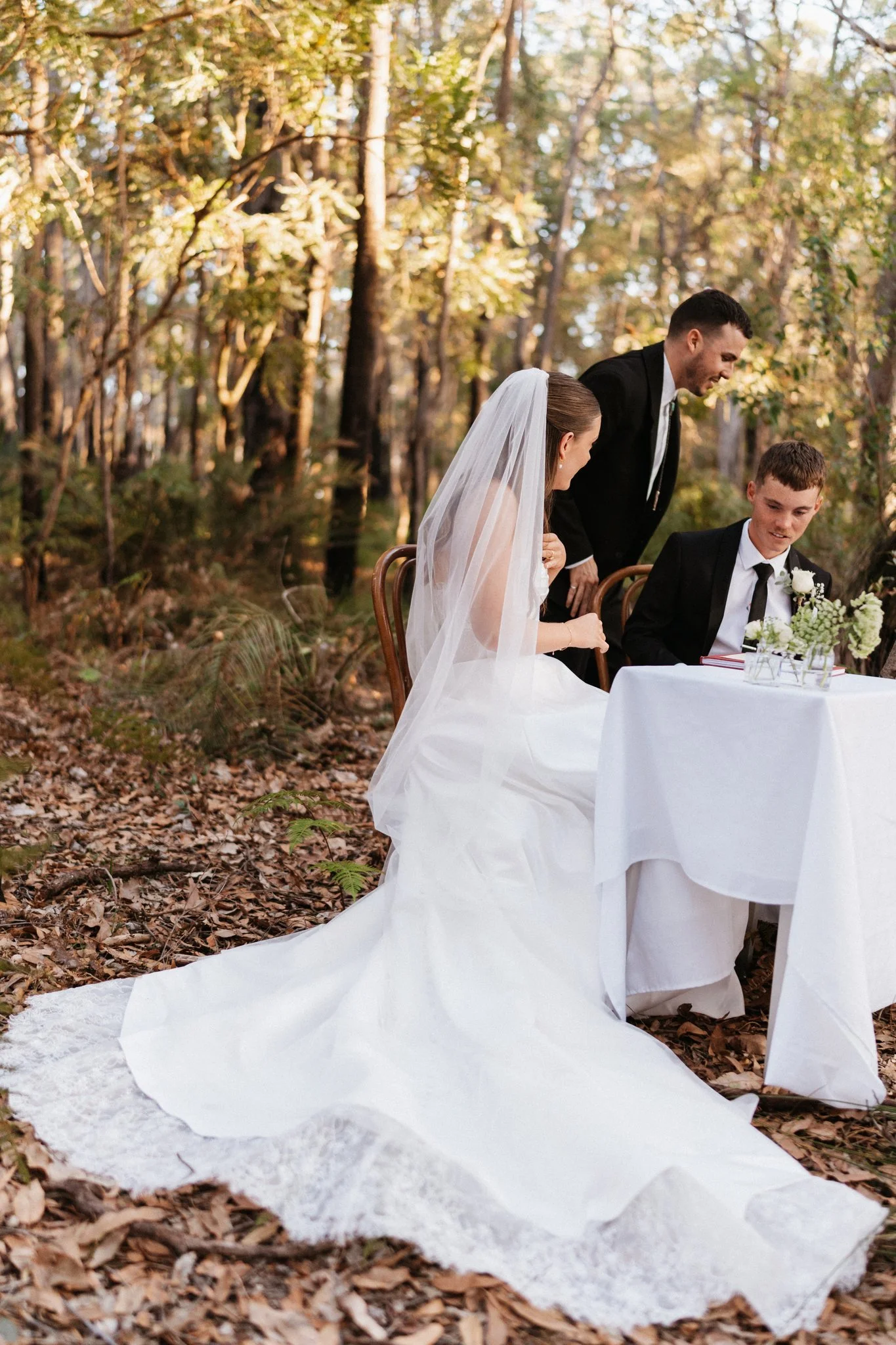 Bride and groom at the signing table among the trees