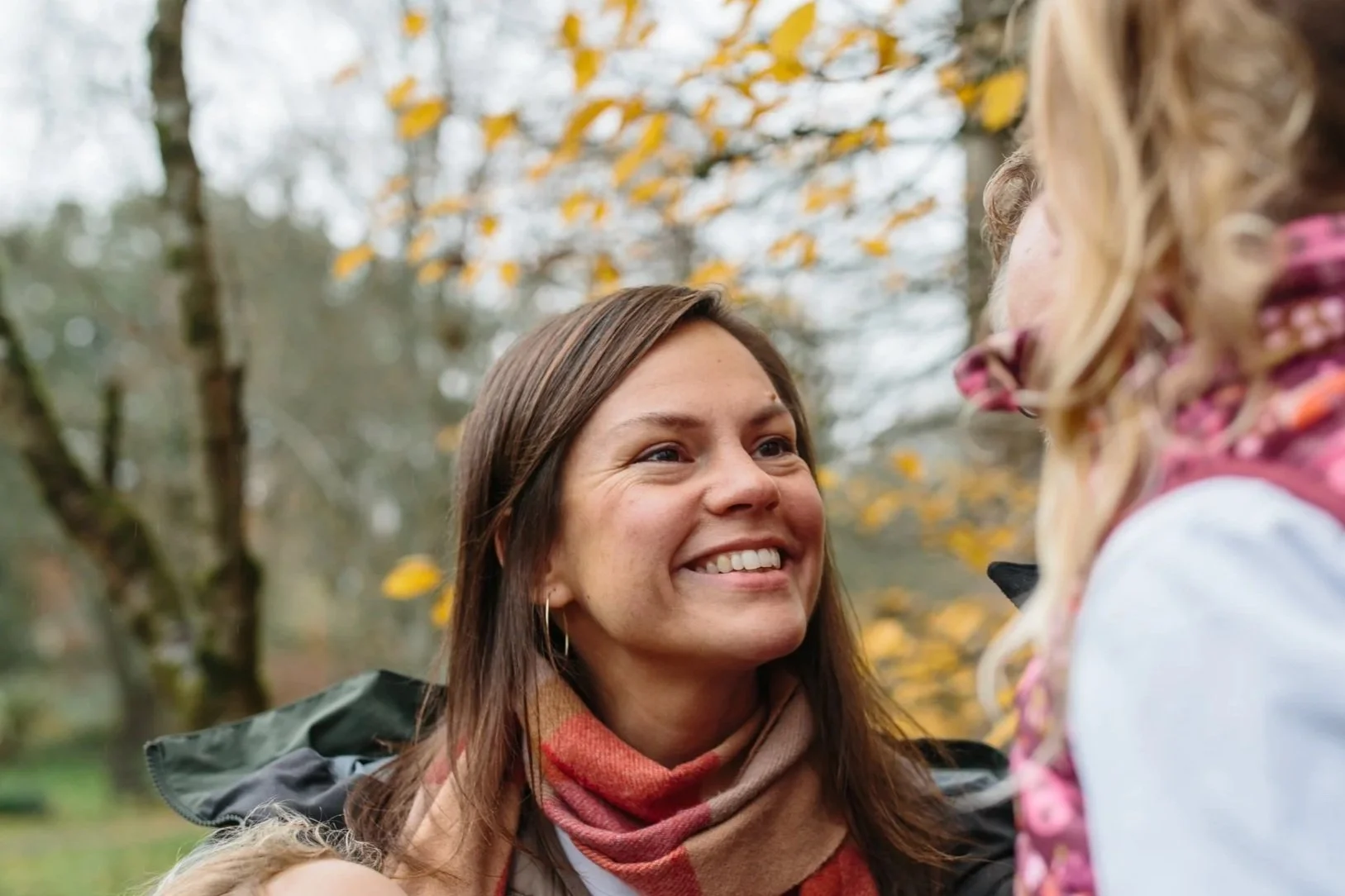 Photo of Sarah standing in a park staring up at her daughter