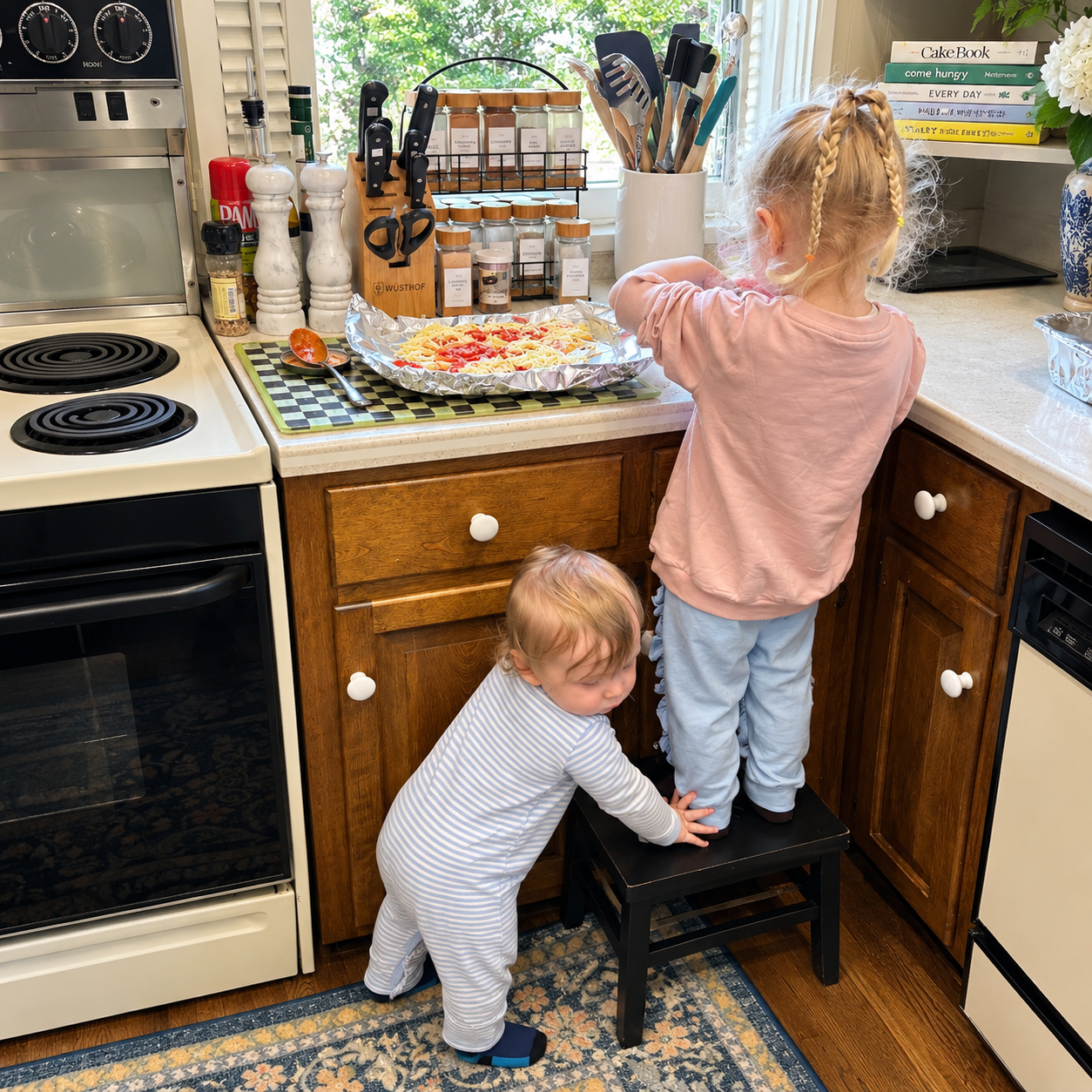 Two young children helping together in the kitchen.