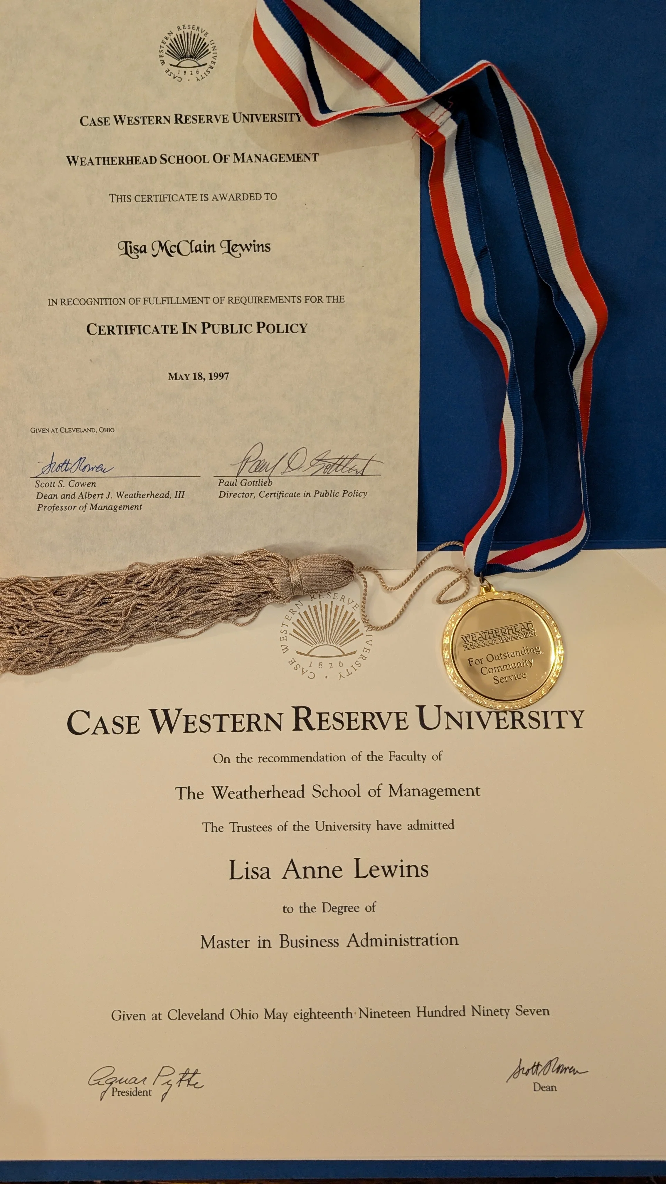 A diploma from Case Western Reserve University awarded to Lisa Lewins for a Master of Business Administration, dated May 18, 1997, with a gold medal for Community Service award . Certificate of Public Policy is at upper left.