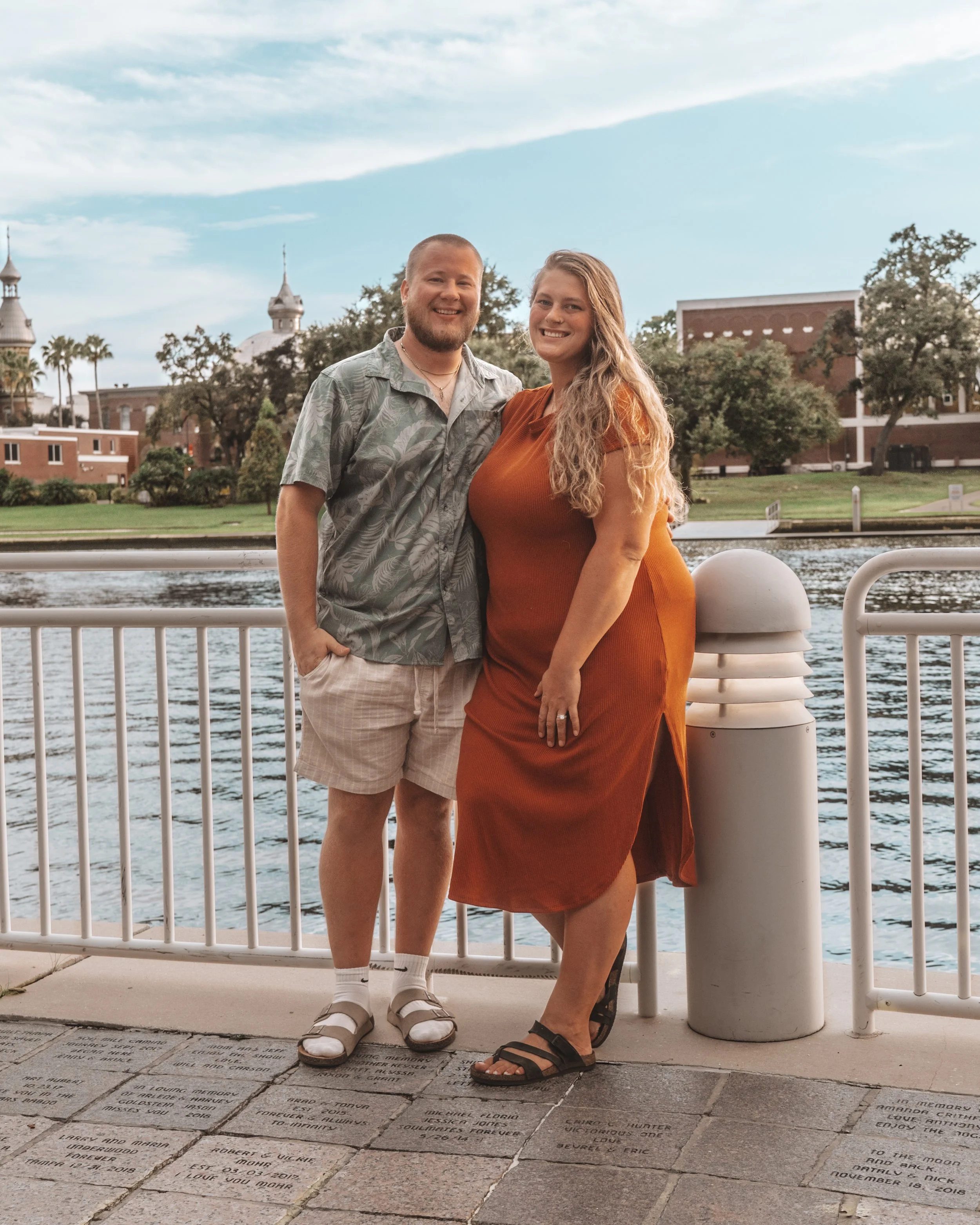 Brad and his wife standing together on a waterfront promenade on the Tampa Riverwalk, downtown Tampa Florida