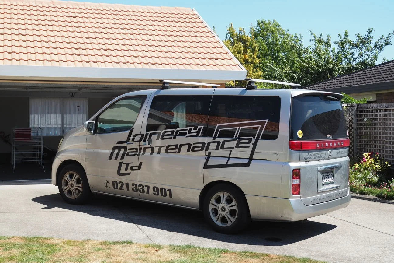 A Joinery Maintenance van parked in front of a suburban house with a garage open to the side.