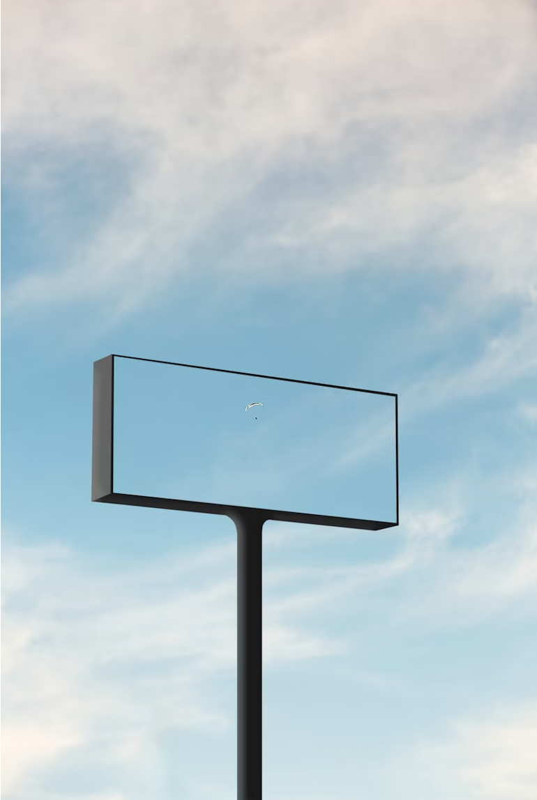 Empty billboard with a clear sky and a small parasail in the background.