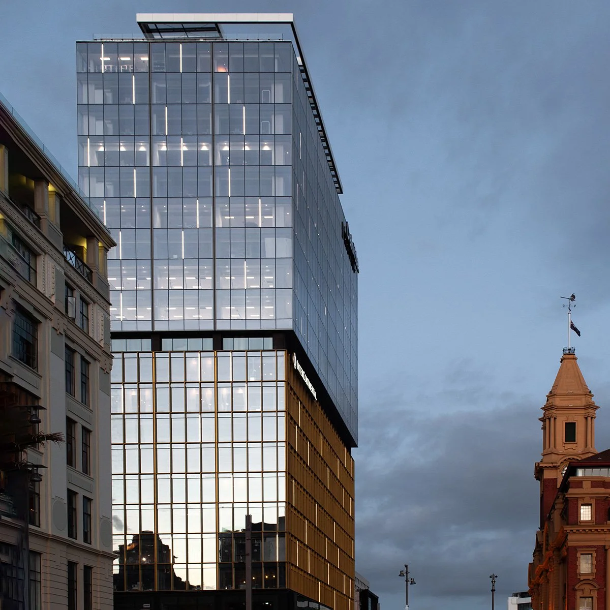Photograph of exterior of Deloitte Centre featuring Paroa Puru work at twlight