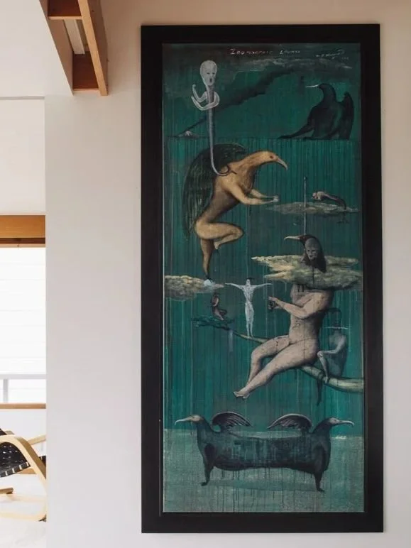 Long vertical Bill Hammond painting on a light interior wall.