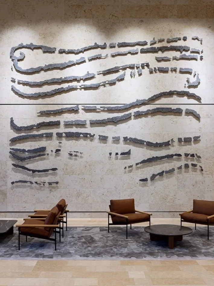 Ana Iti large sculptural work on a wall in a public foyer.