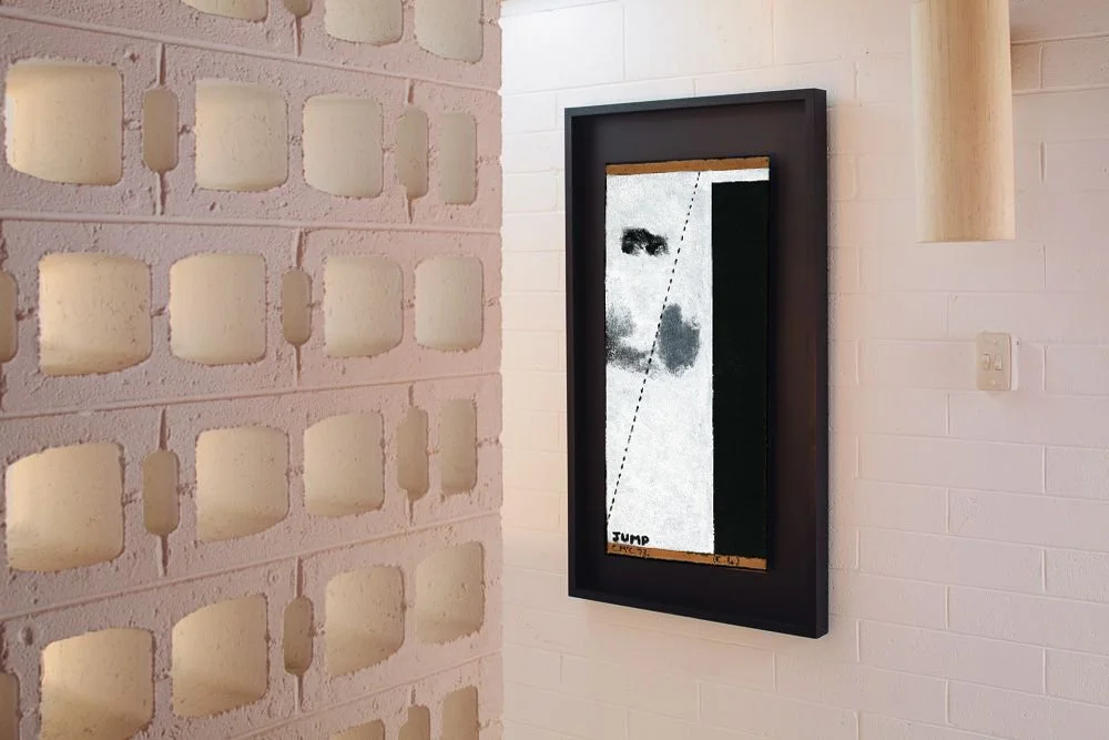 Framed Colin McCahon work on a light wall.