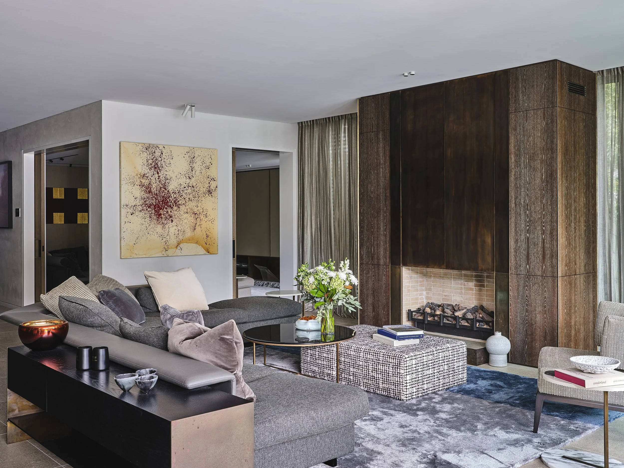 Modern living room with a large abstract painting on the main wall.