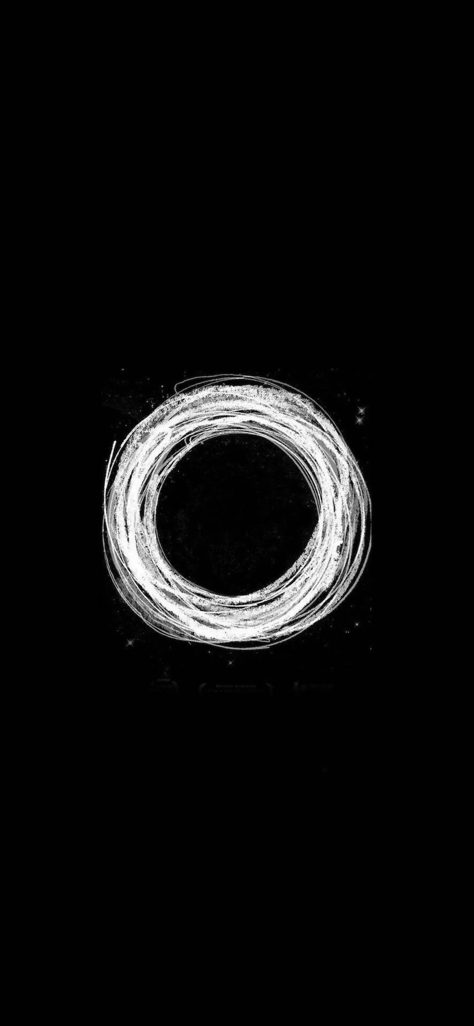 A white, glowing circular design resembling a torus or an energy ring, set against a black background with faint star-like specks.