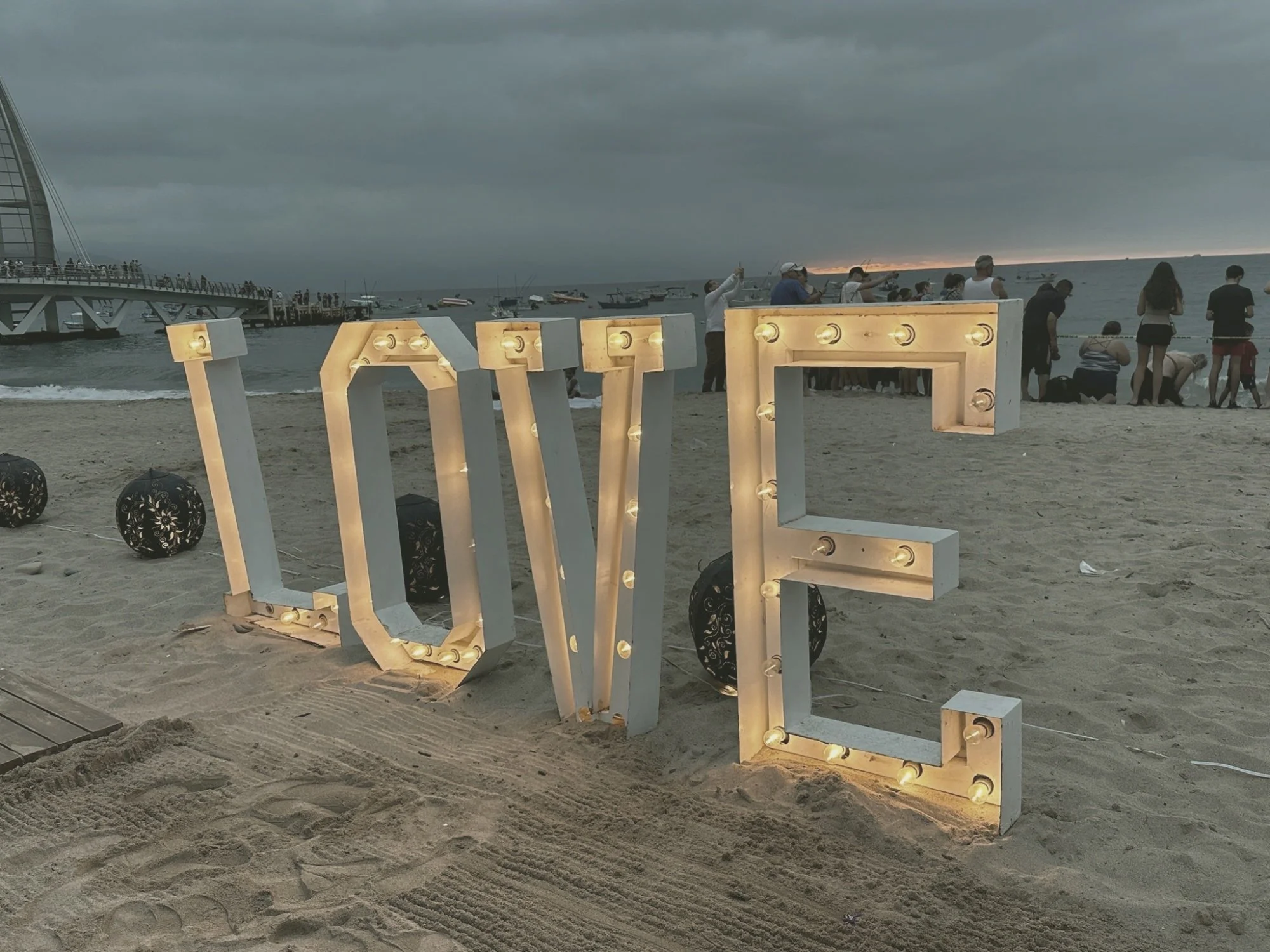 Lighted LOVE letters on a beach at dusk