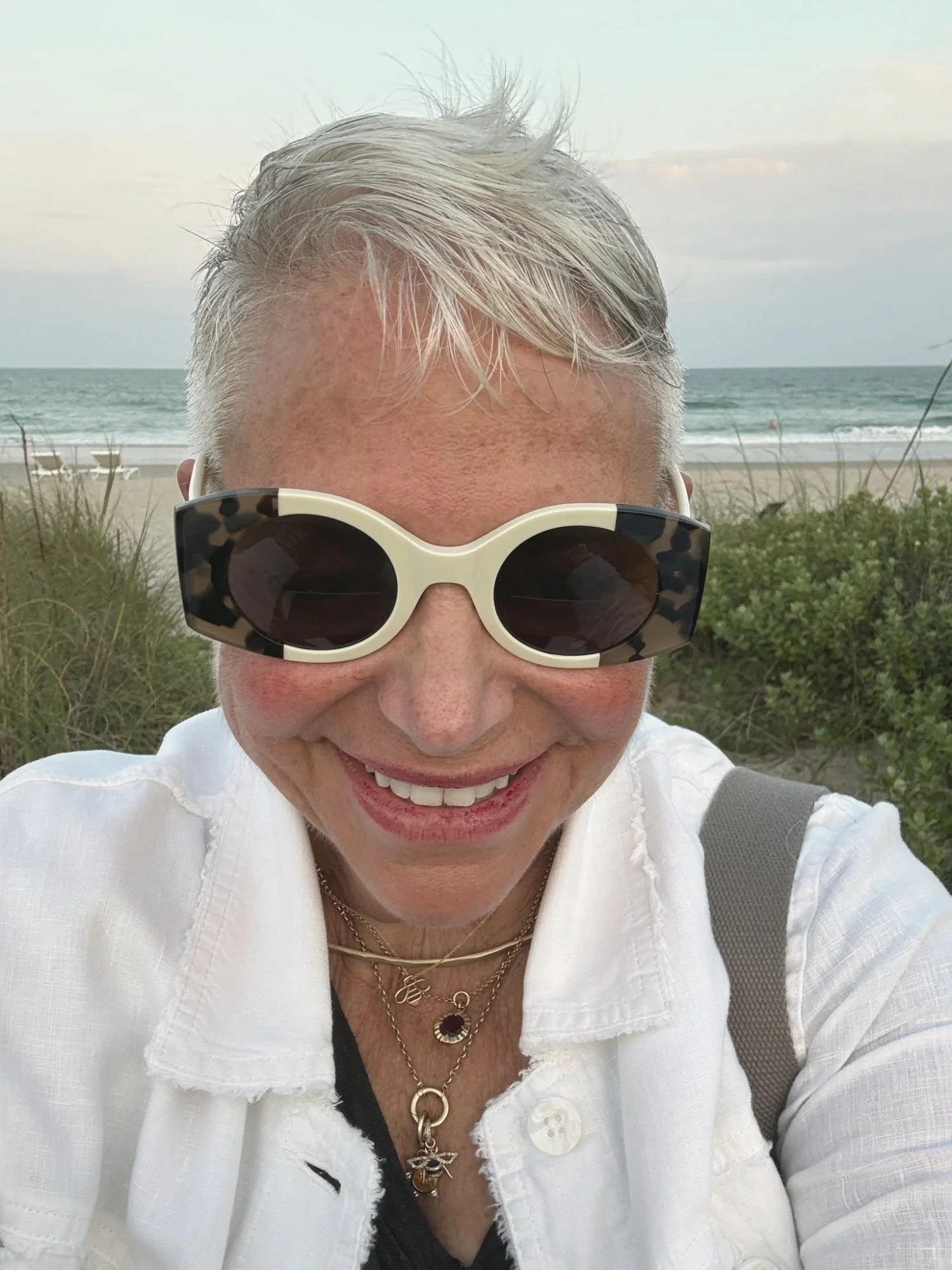 Eve Ruff smiling at the beach in white linen
