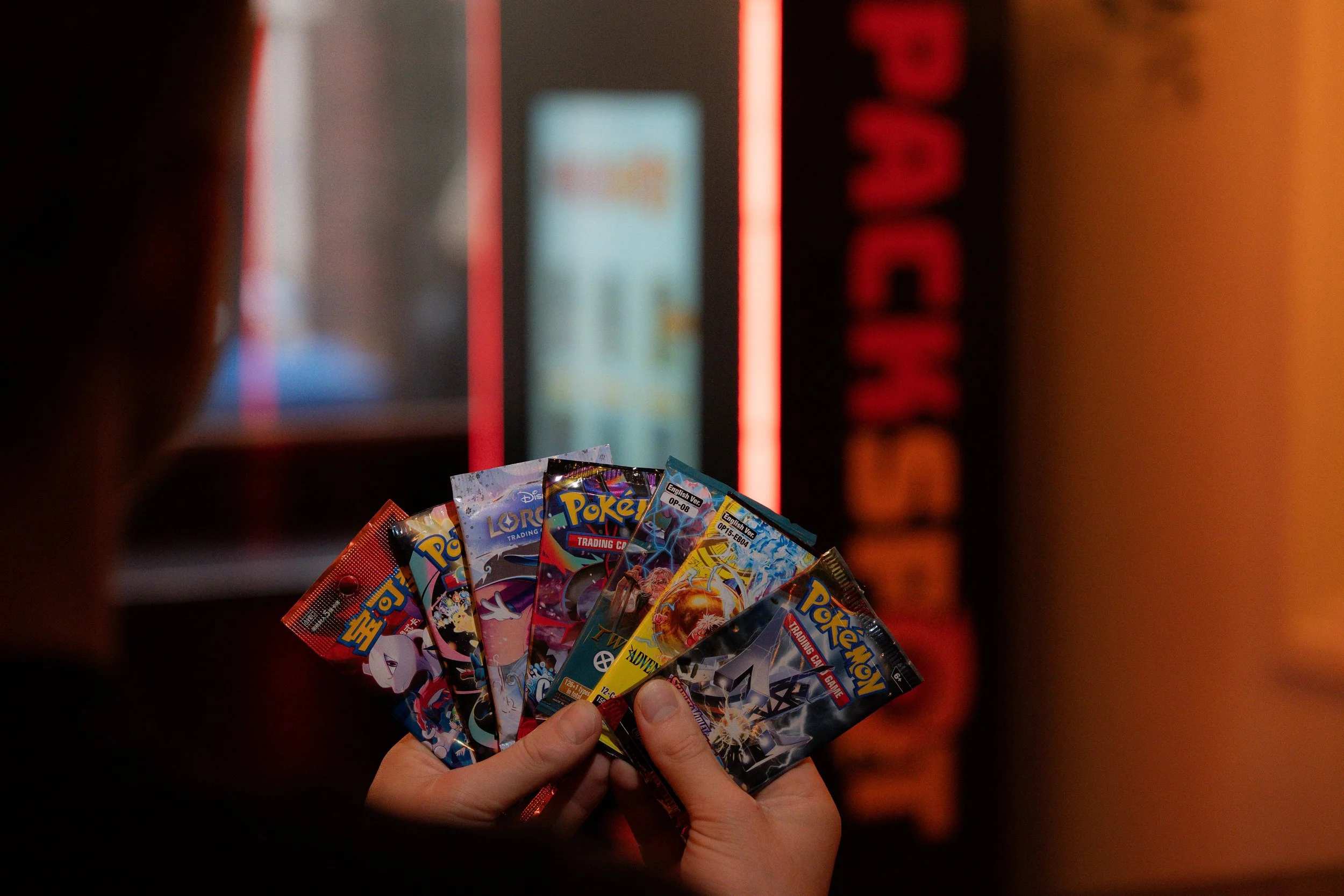 Someone showing TCG packs with a Packspot vending machine in the background