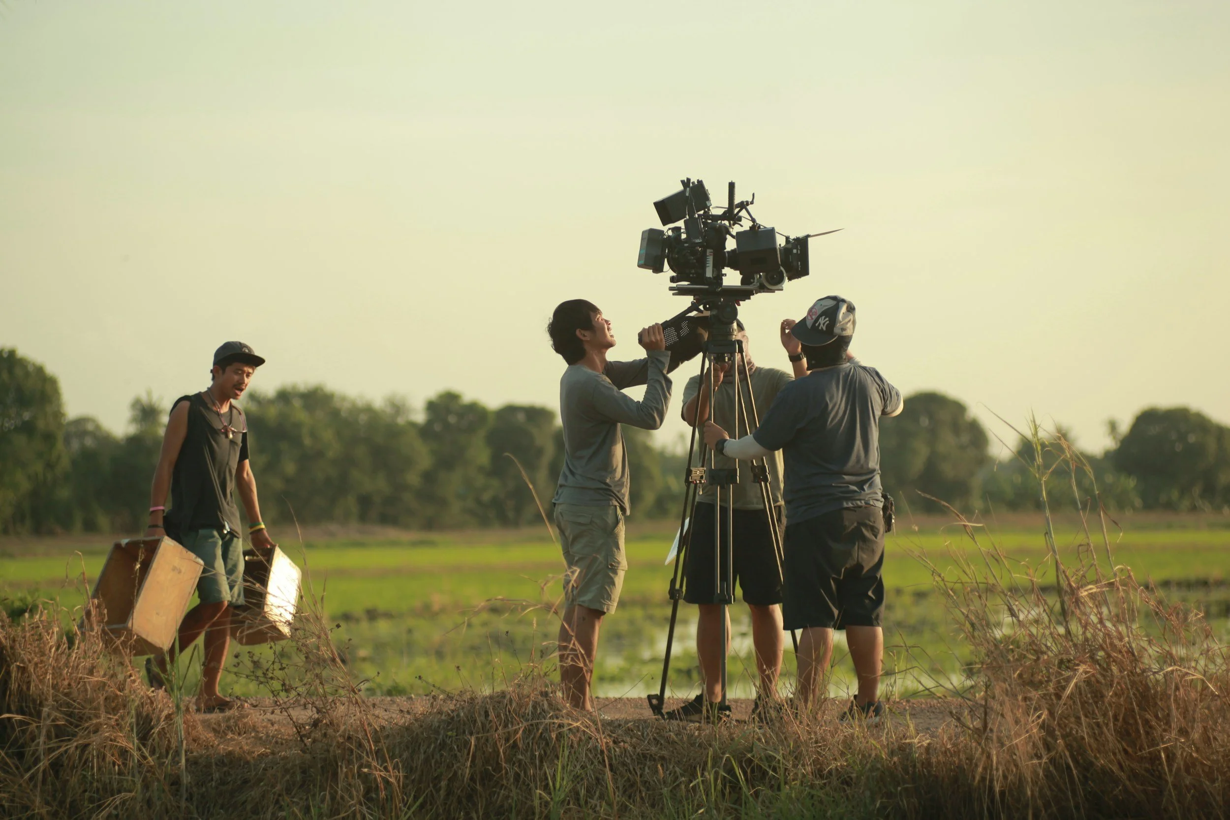 Impact story documentary crew setting up a camera shot outdoors during a golden hour shoot