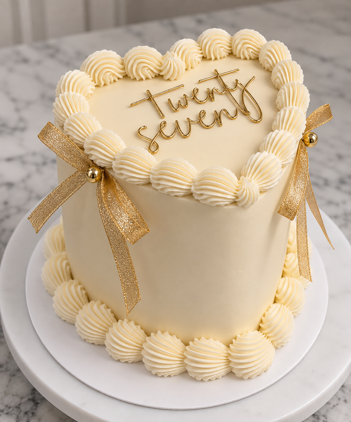 A heart-shaped wedding cake decorated with white frosting, gold ribbons, and a gold 'treat sweet' message on top.