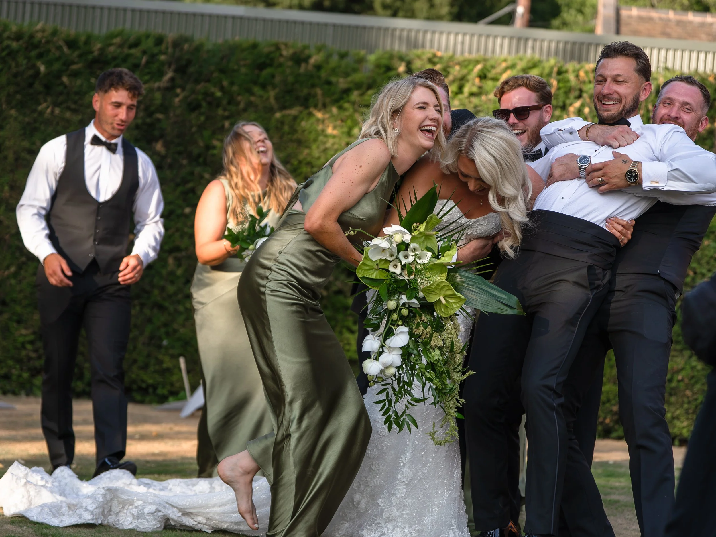 Bridal party wedding photo showing the group having fun and running towards the bride and groom.