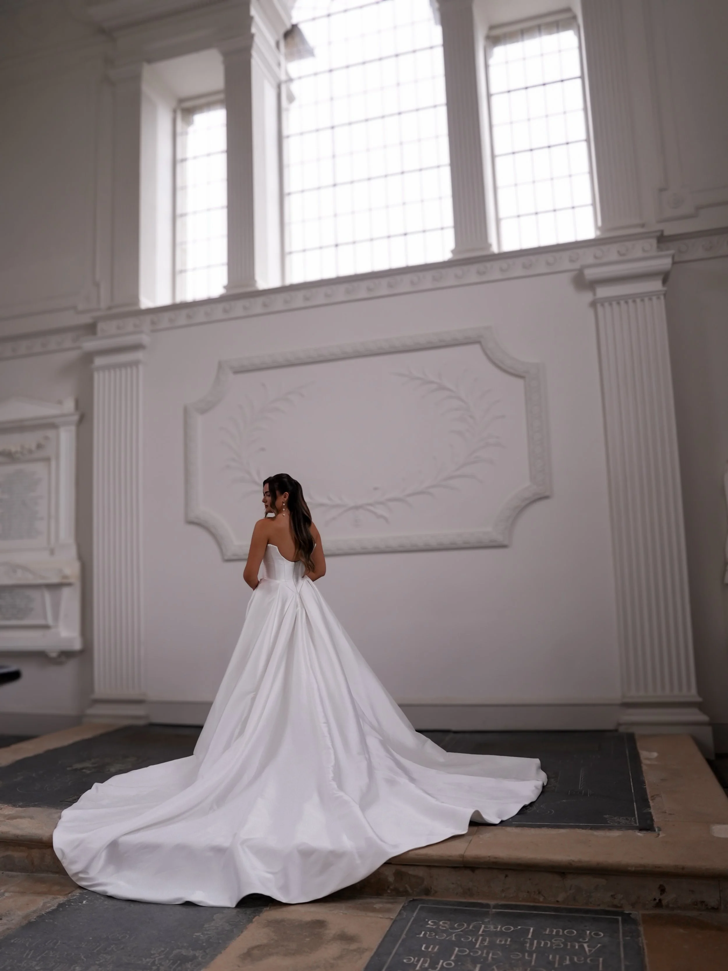 A bride at Compton Verney wearing a plain A line wedding dress called Orlee by Willow Victoria showcasing its long train.