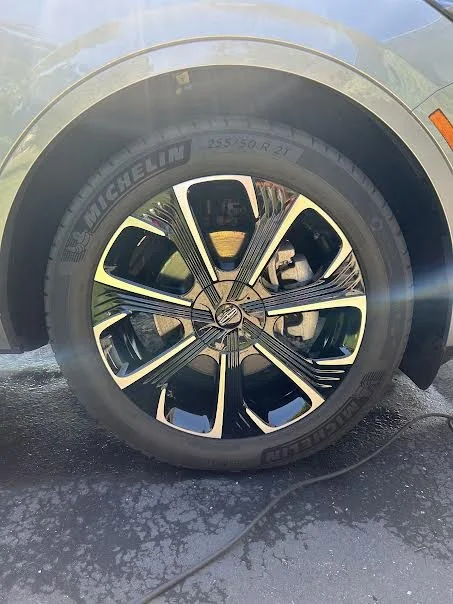 Close-up of a car tire with a stylish alloy wheel, mounted on a vehicle with a Michelin tire brand visible.