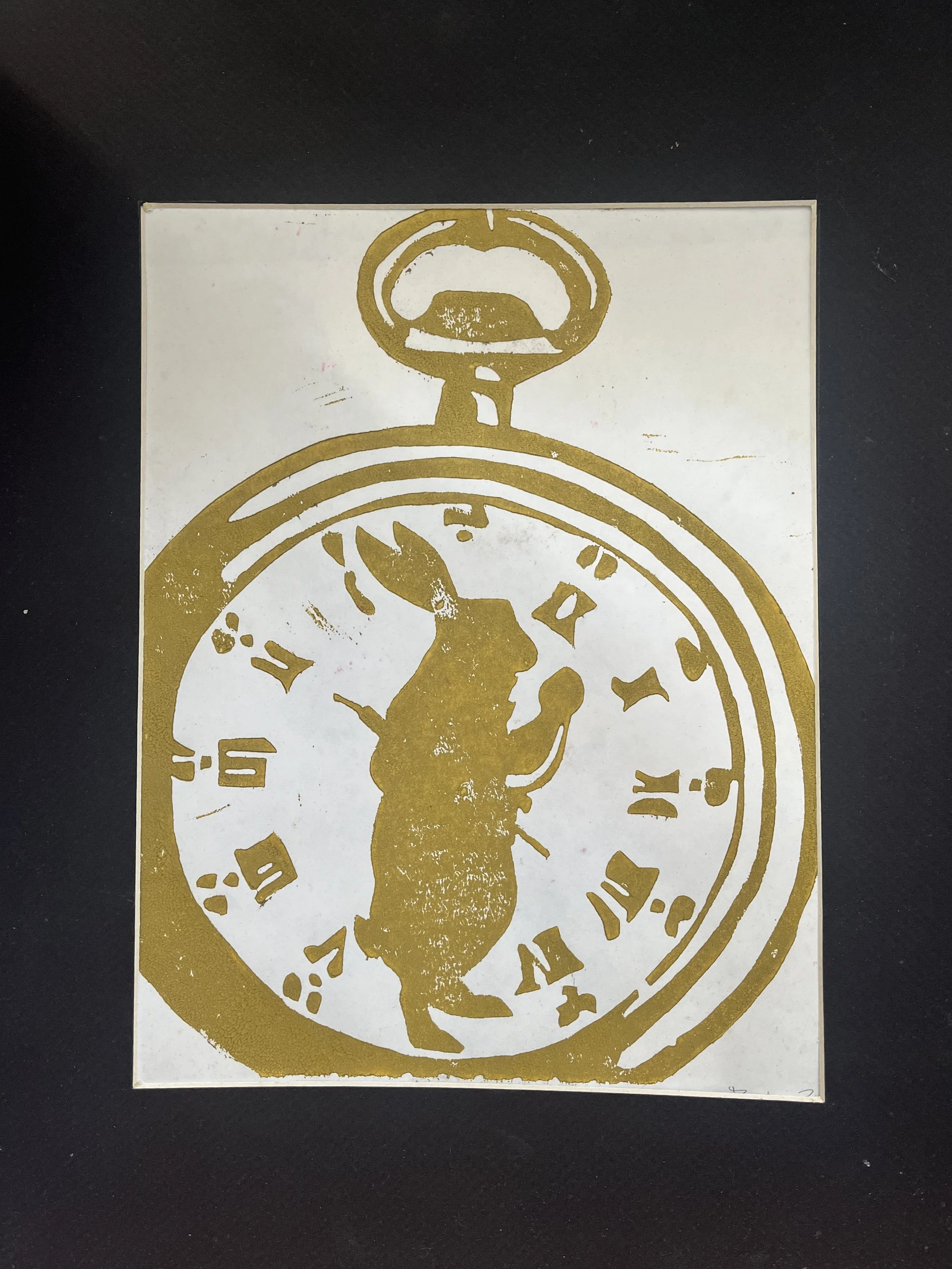 A gold-colored stencil of a clock face with Roman numerals and a figure of a person standing in front of it.