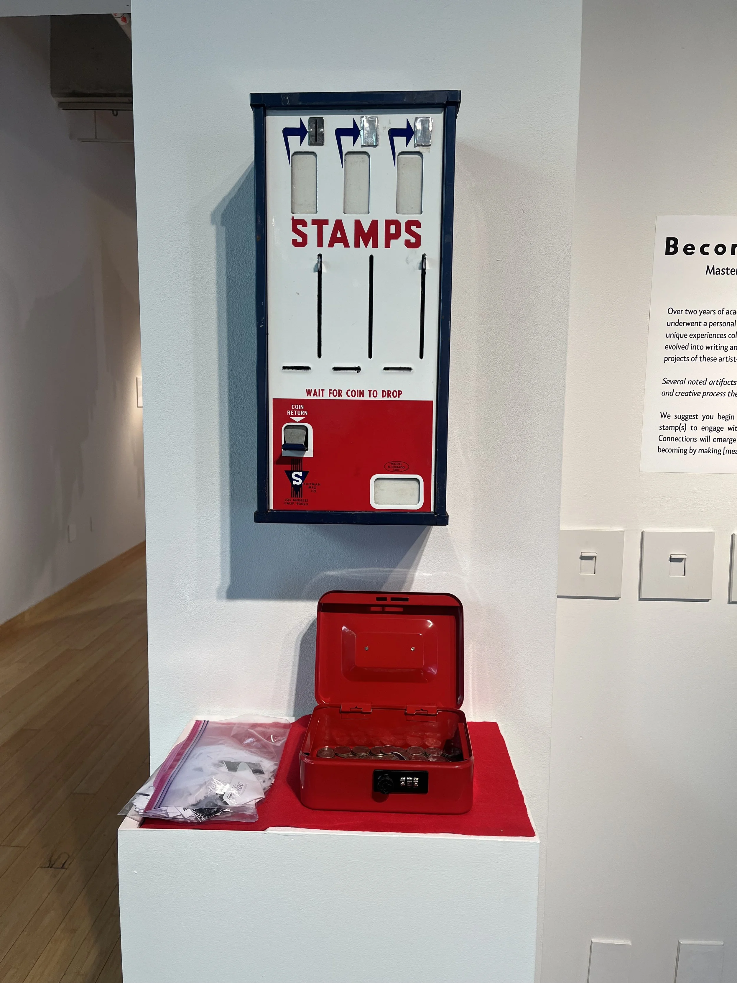 A coin stamp distribution box mounted on a white wall, with a red coin collection box open below it.