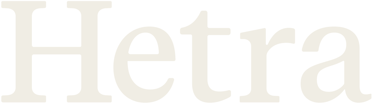 Close-up of the word 'Hetra' written in large, beige letters on a black background.