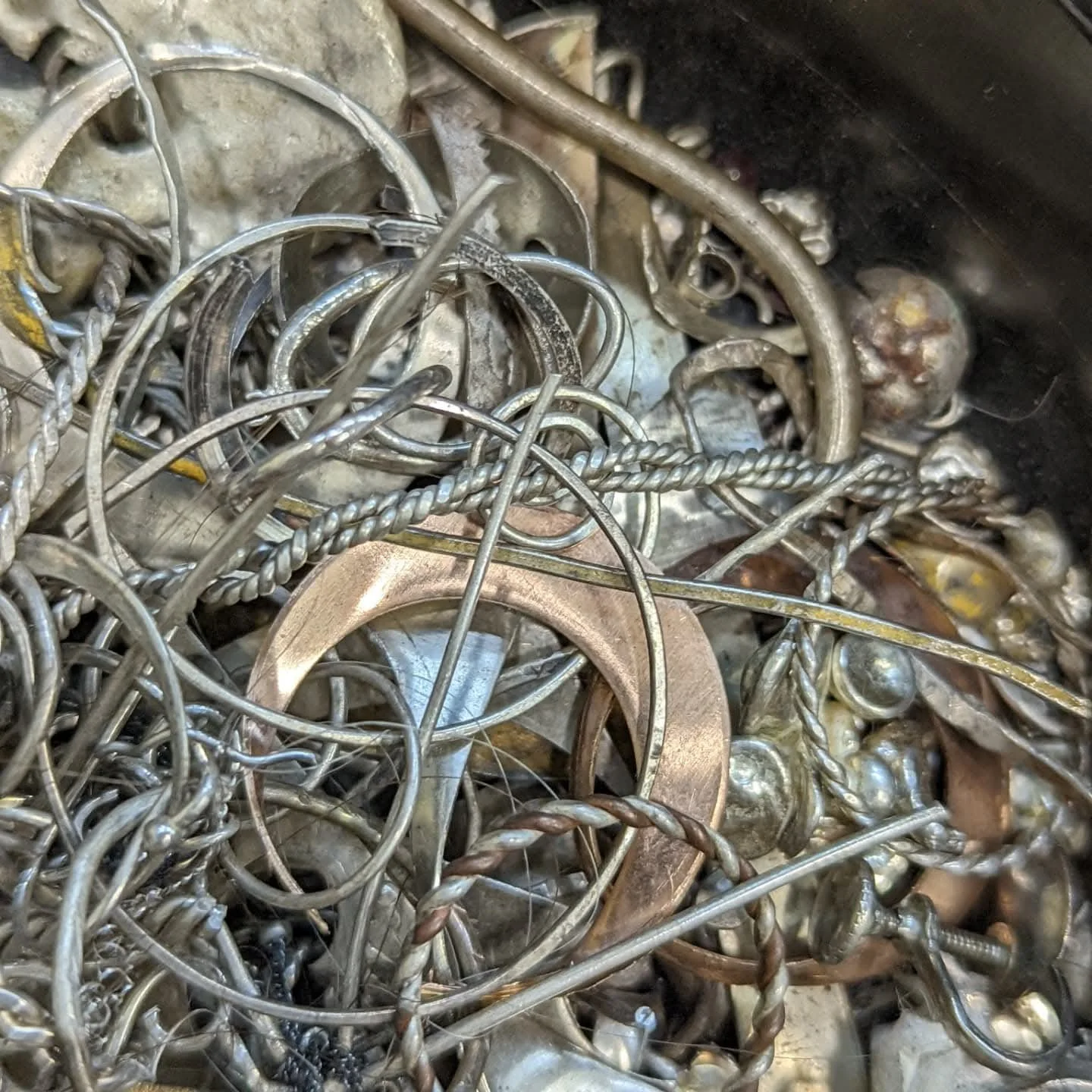 A tangled pile of various metal scrap, including wire, rings, and small metal pieces.