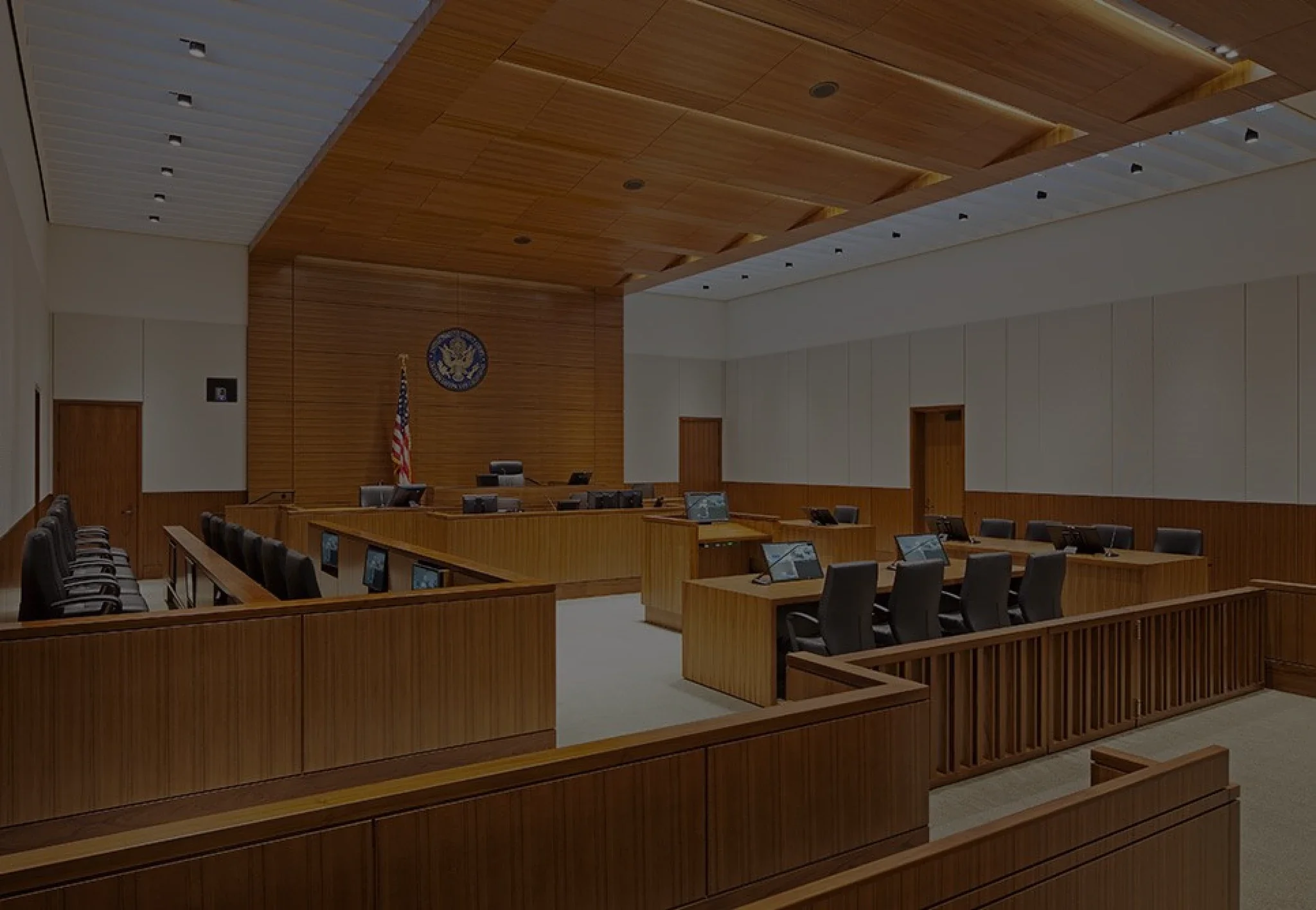 Courtroom with wood paneling, an American flag and a government seal, where immigration and criminal cases are heard