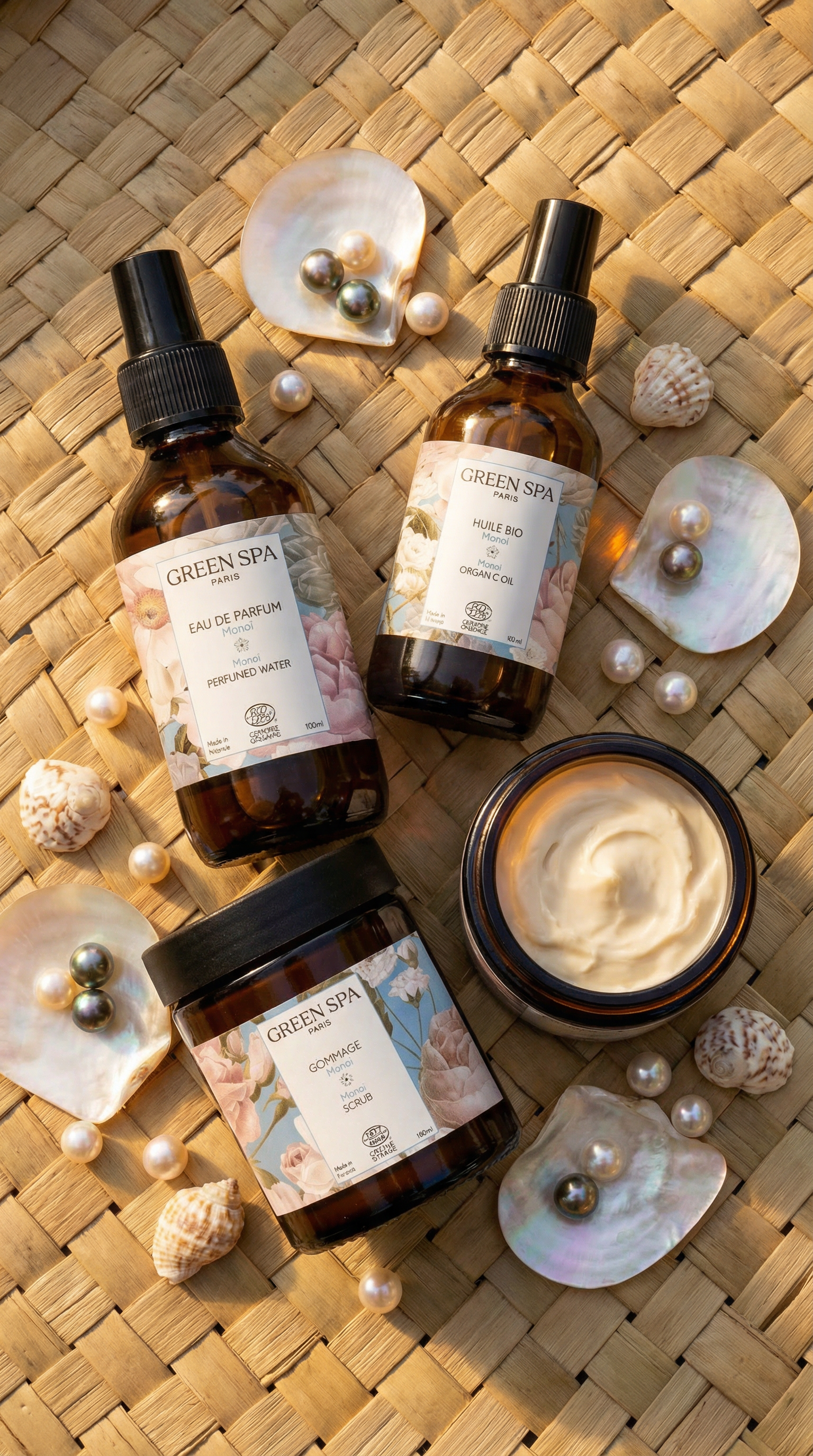 Produits de spa Green Spa avec huiles biologiques, eau de parfum, gommage et crème, entourés de coquillages et perles sur un tapis en osier.