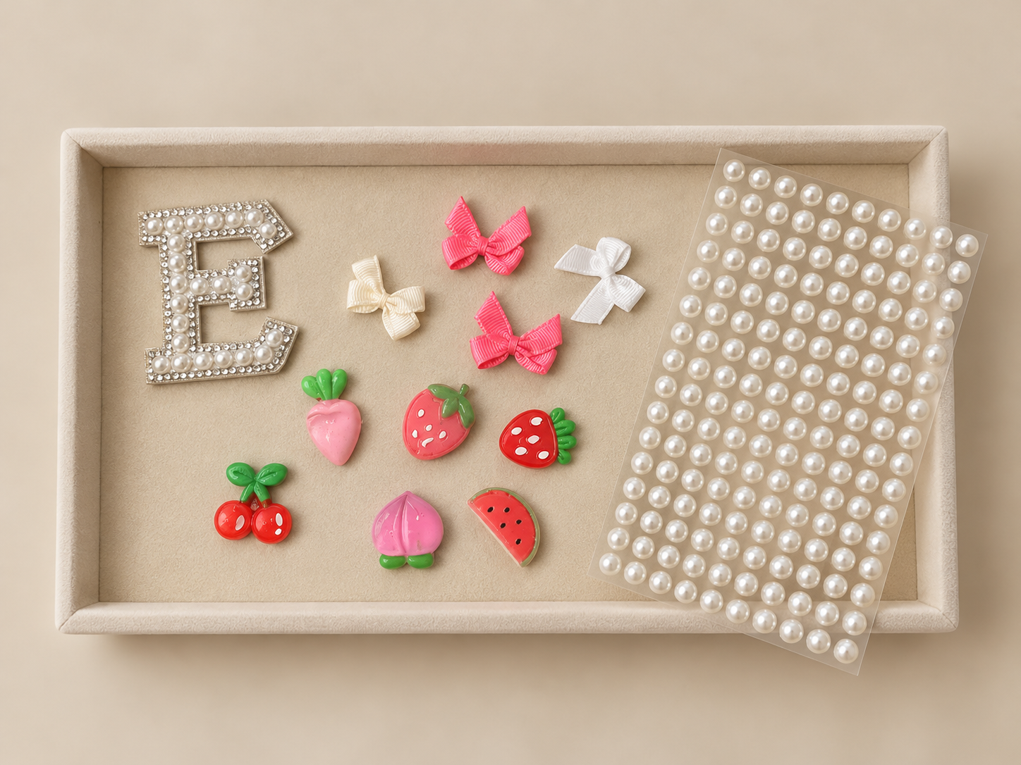 A tray featuring colorful resin charms and pearls.