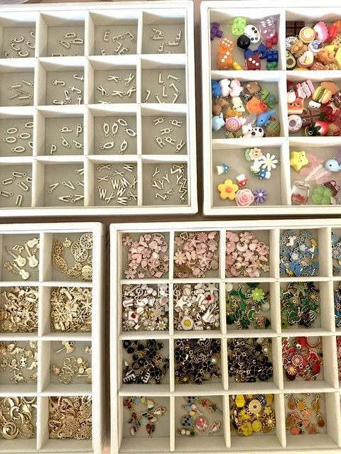 Trays of gold and colorful charms.