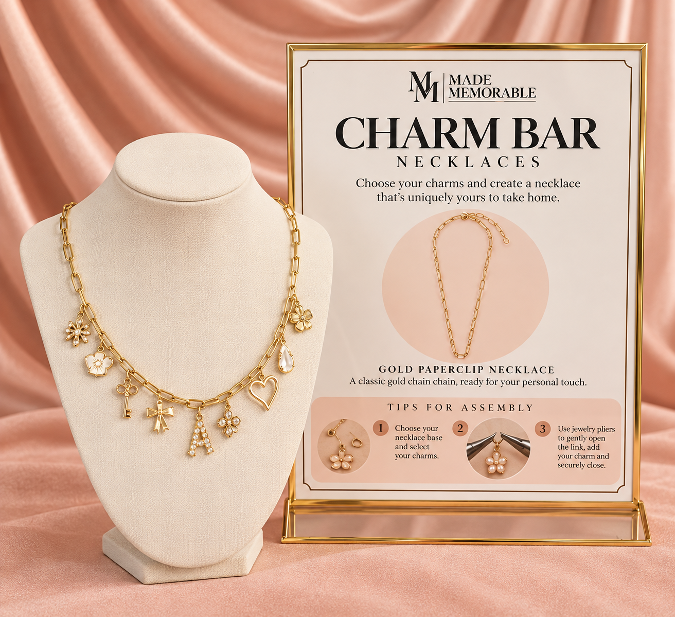 A gold charm necklace on a jewelry display bust with a sign describing charm bracelet necklaces, featuring tips for assembly.
