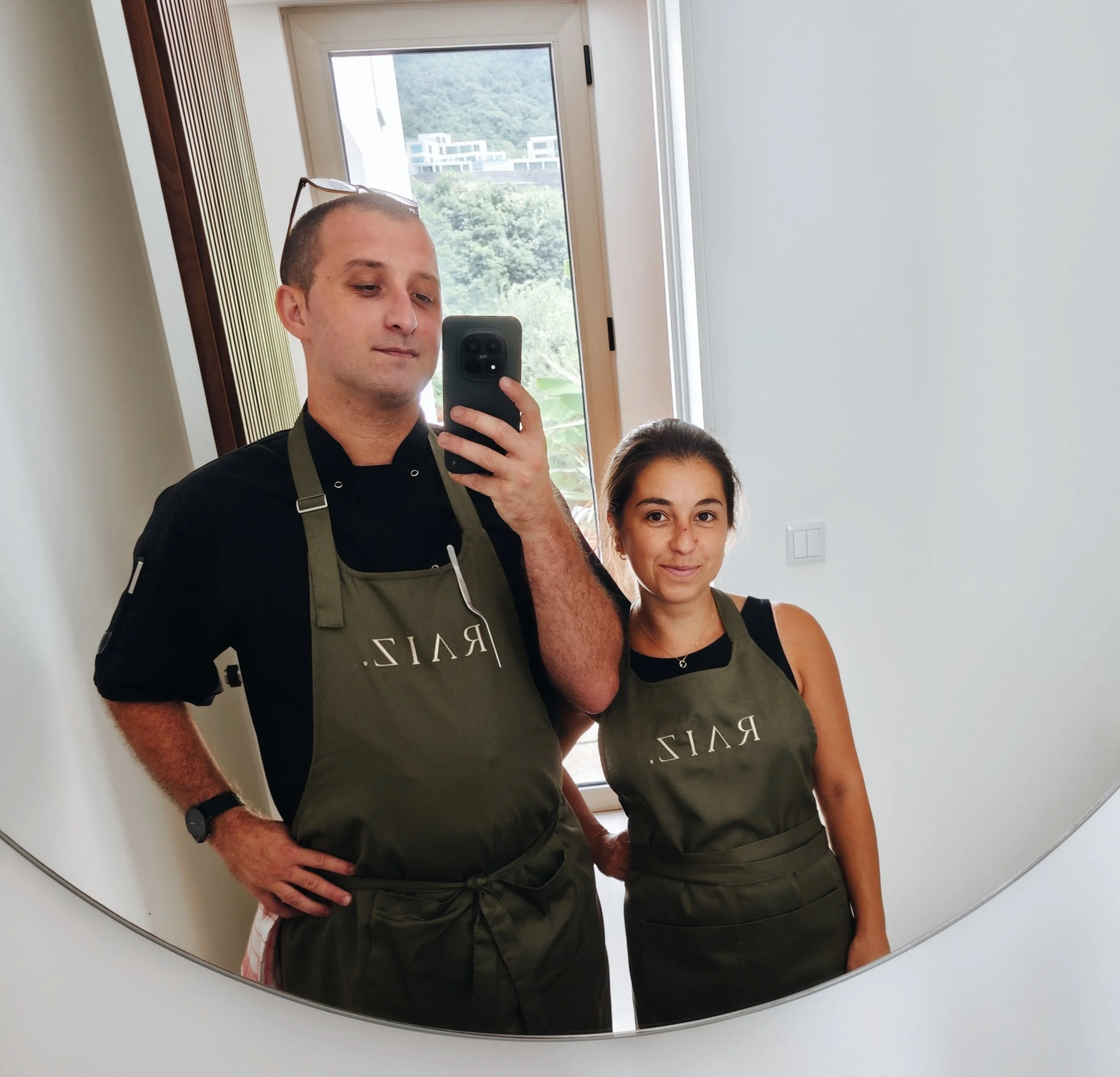 Two people wearing RAIZ. aprons photographed together