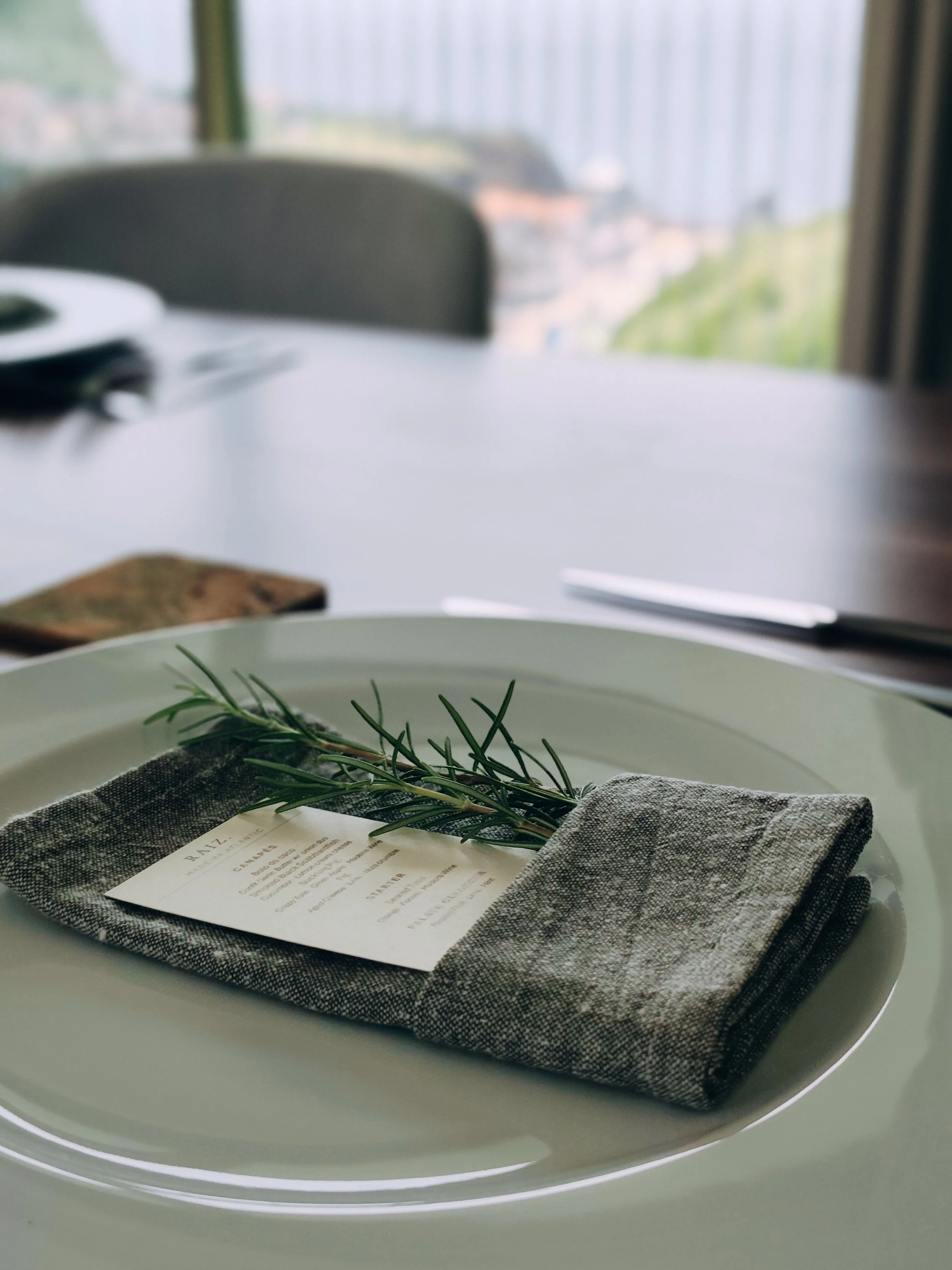 Place setting with linen napkin, rosemary and personalised card