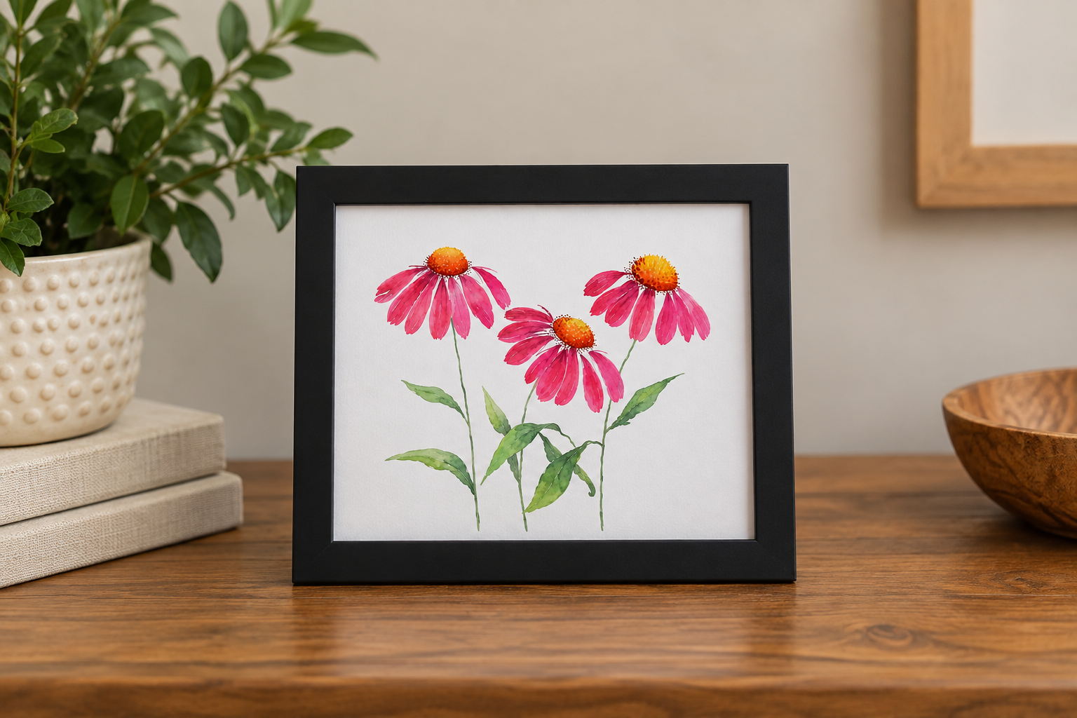 Pink Cosmos 8x10 botanical print displayed in a black frame on a warm wood surface with neutral home décor and greenery.