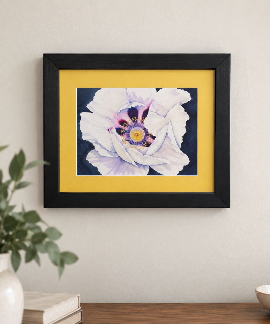 Quiet Bloom framed floral watercolor print displayed on a neutral wall, featuring a white and lavender flower surrounded by a golden-yellow mat and black 8x10 frame.