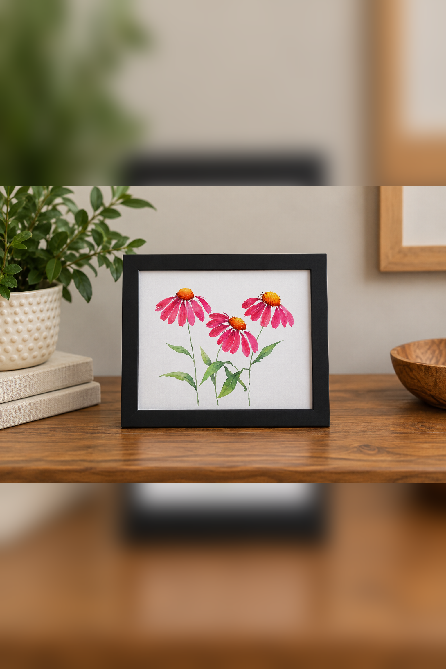 Pink Cosmos 8x10 botanical print displayed in a black frame on a warm wood surface with neutral home décor and greenery.