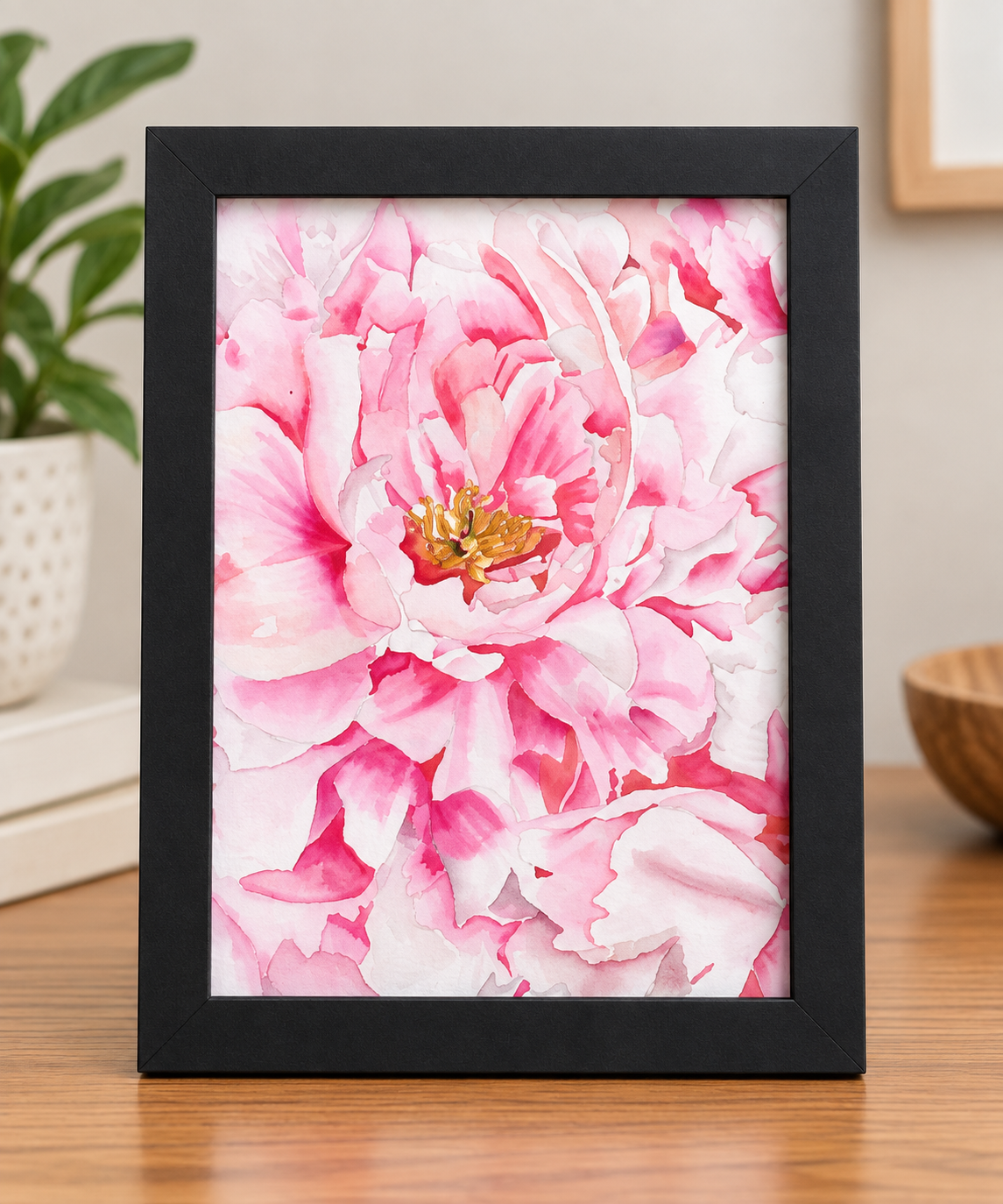 Petal Upon Petal pink peony watercolor print displayed in a black 8x10 frame on a warm wood surface.