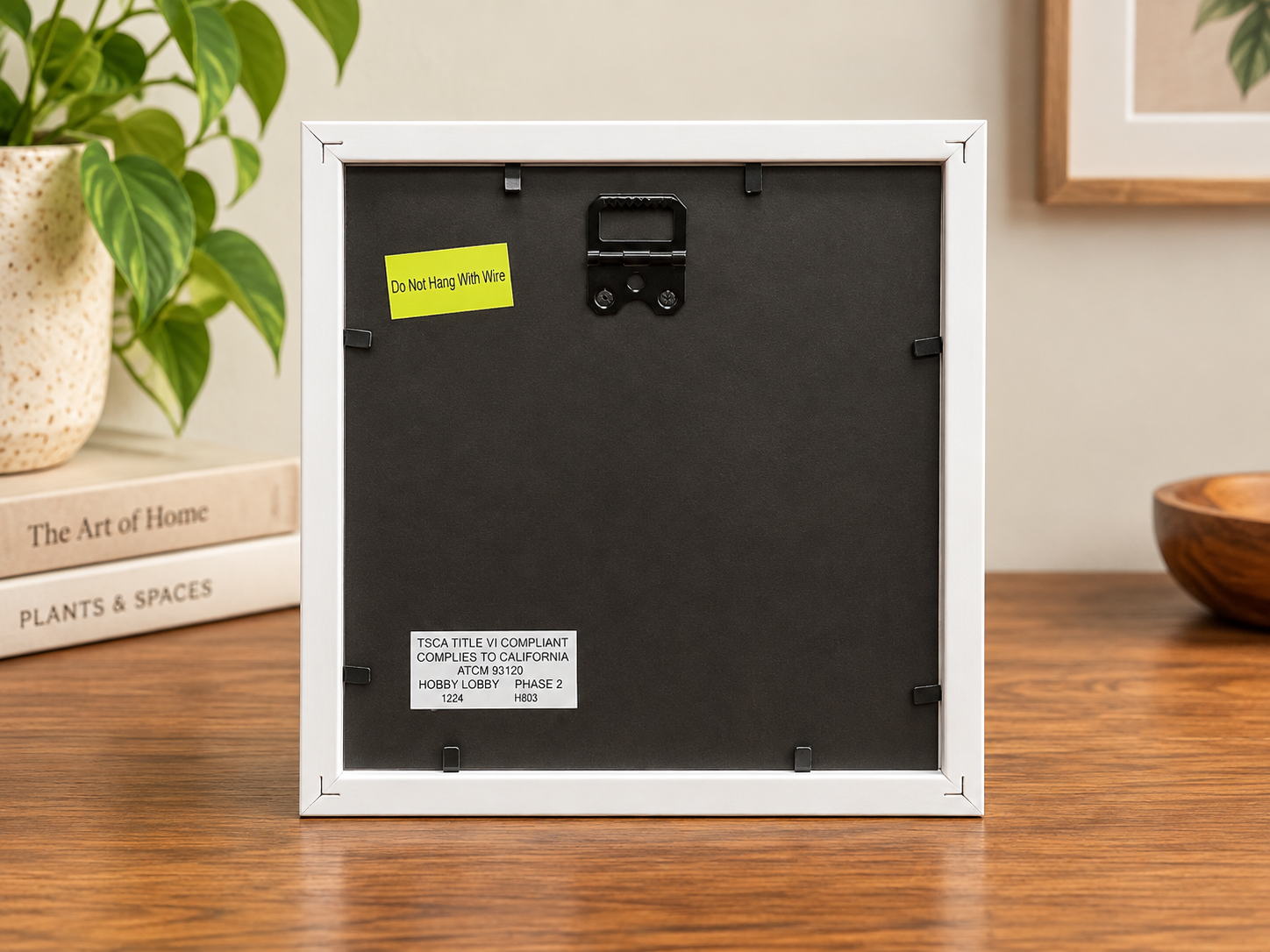 Back of the 8x8 Blushing Peony white frame showing black backing, frame fasteners, hanging hardware, and product labels.